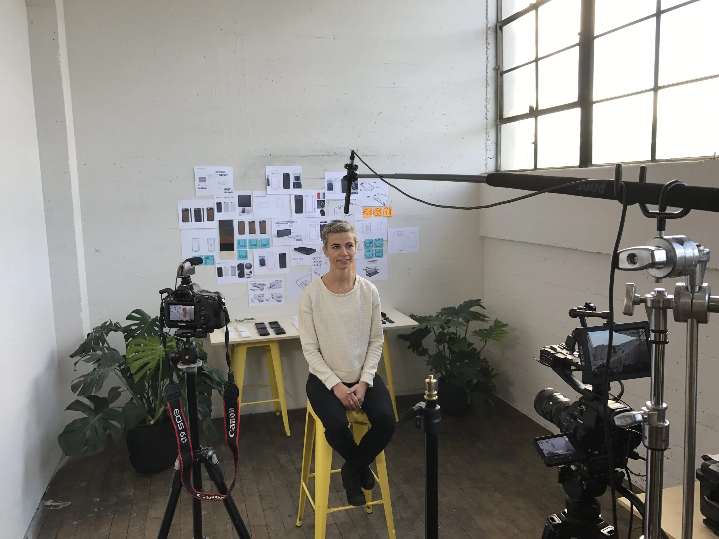 Seated subject surrounded by cameras and lighting during a Moment video interview setup.