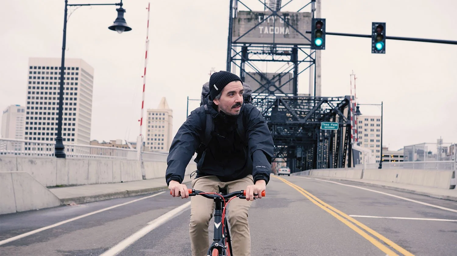 Cyclist wearing a backpack riding across a bridge in downtown Tacoma, Washington.