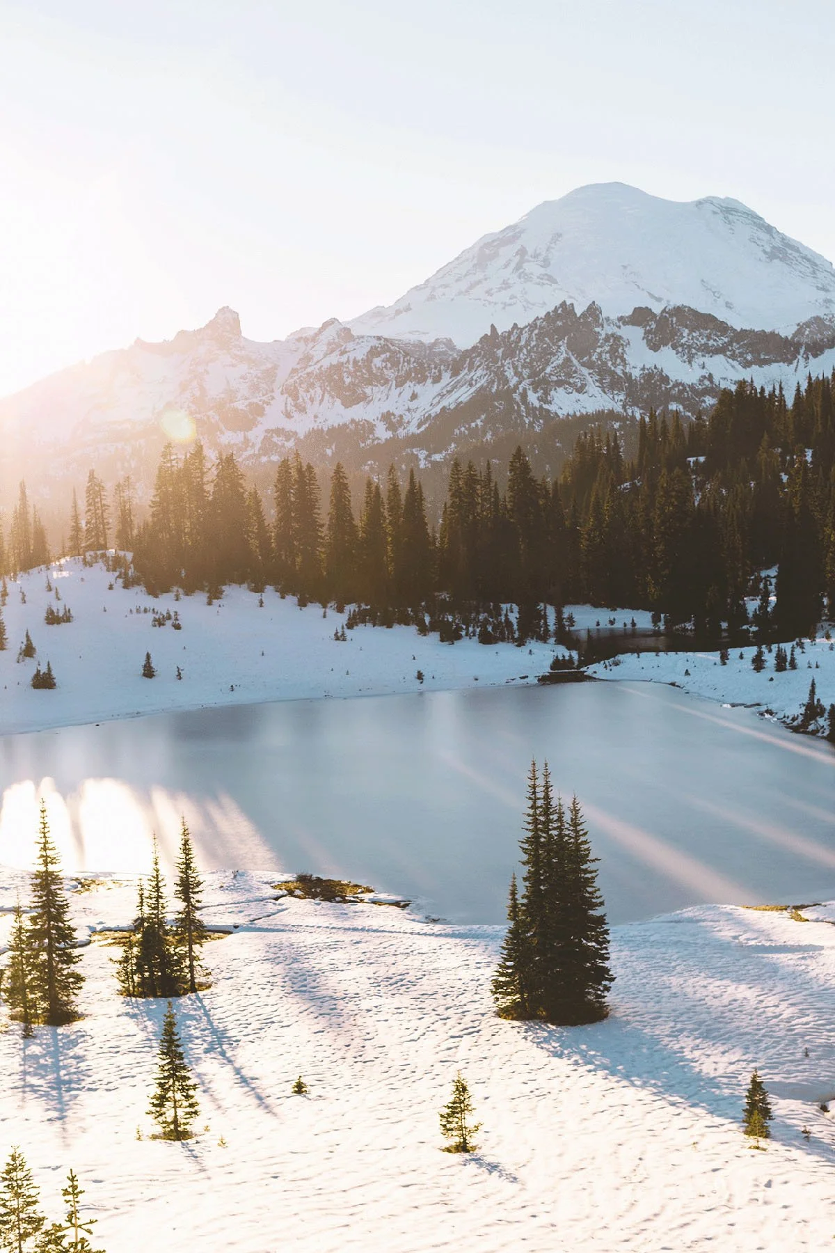 Snow-covered mountain landscape illuminated by warm evening light.