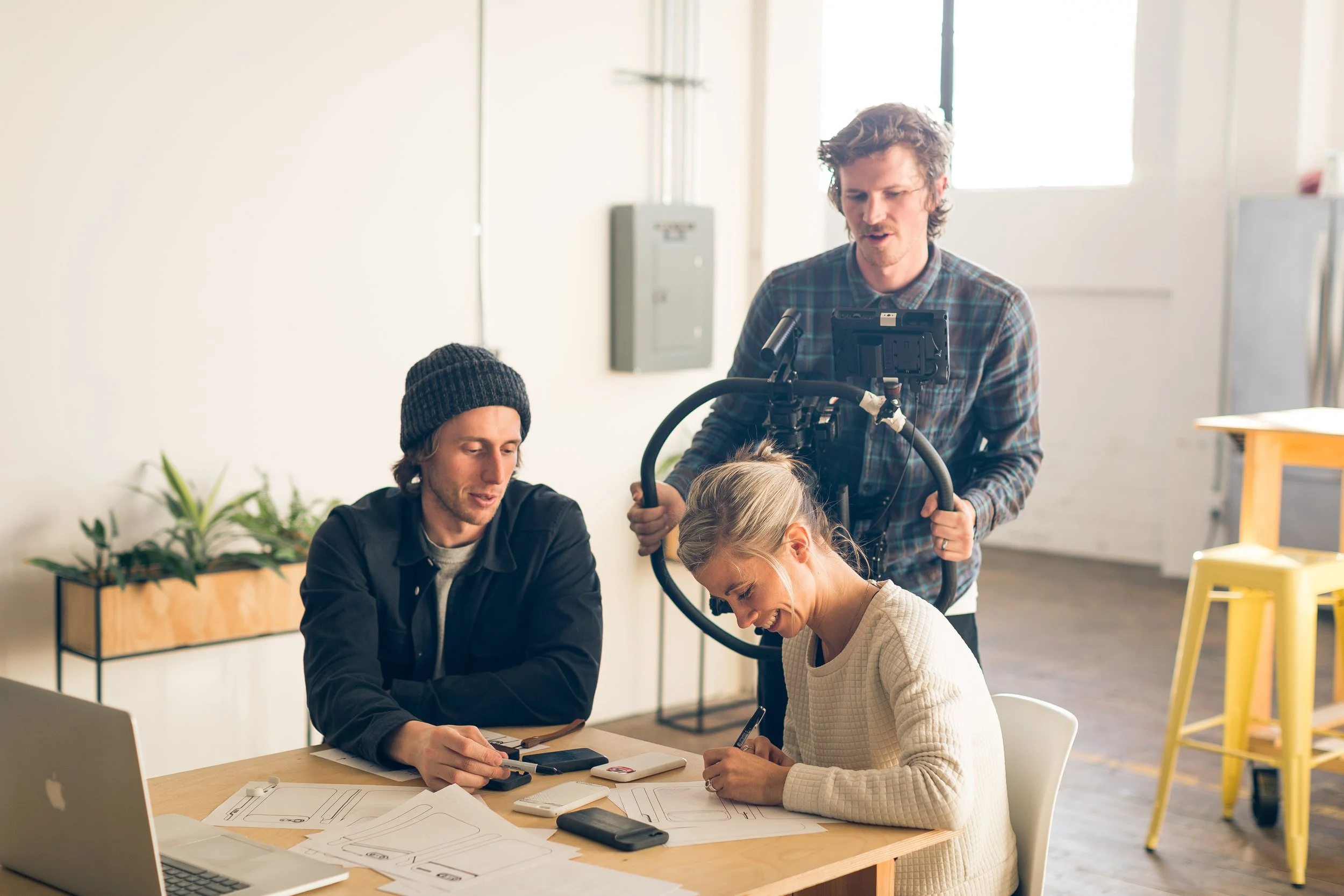 Moment team members reviewing products and notes around a worktable.
