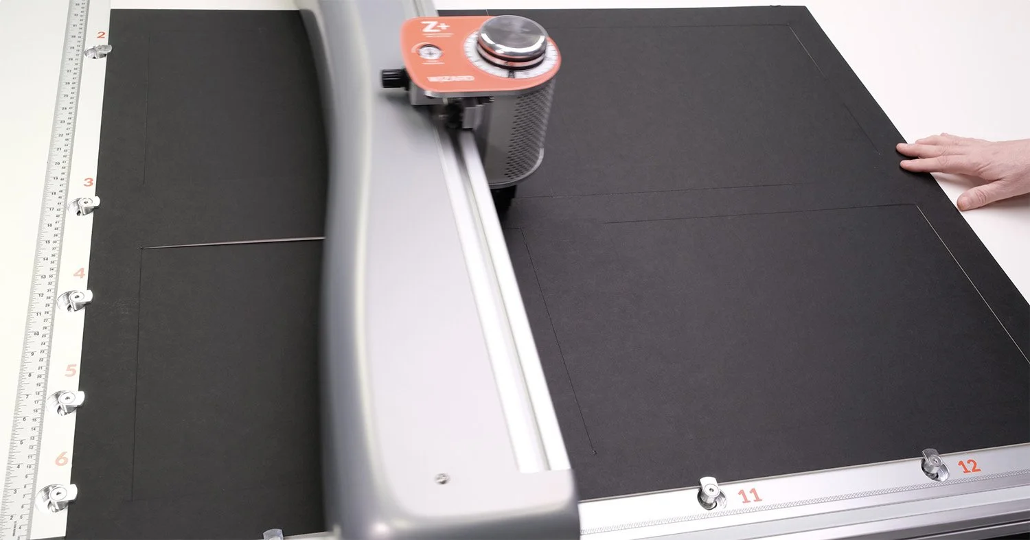 Wizard Z+ cutting head moving across black matboard on a computerized mat cutter.