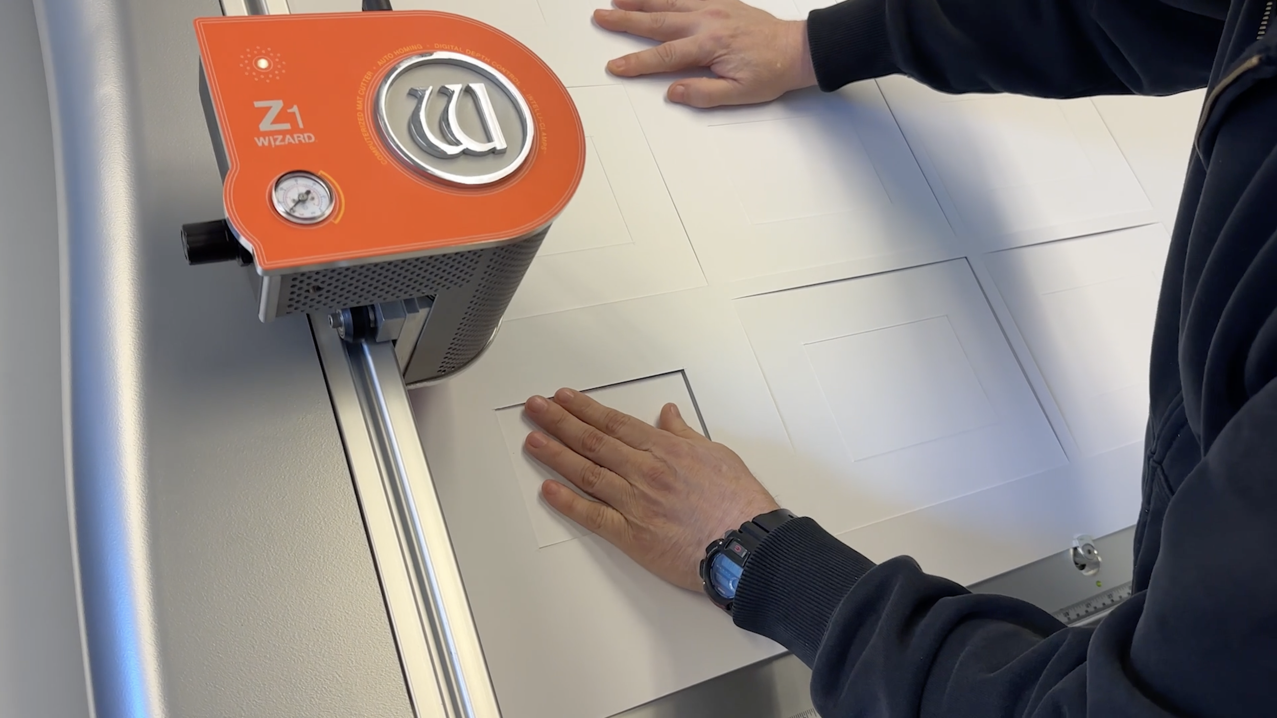 Wizard Z1 cutting matboard while an operator guides material across the machine.
