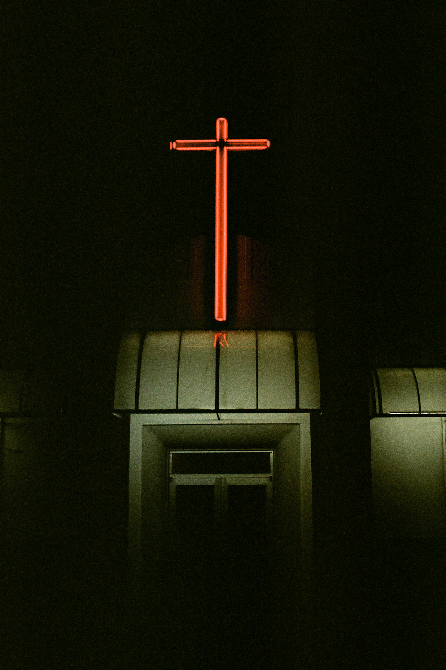 Orange cross glowing above a dark building at night in Everett, Washington.