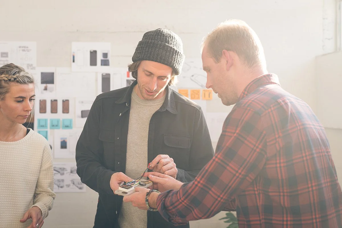 Moment team members reviewing a mobile photography product during development.