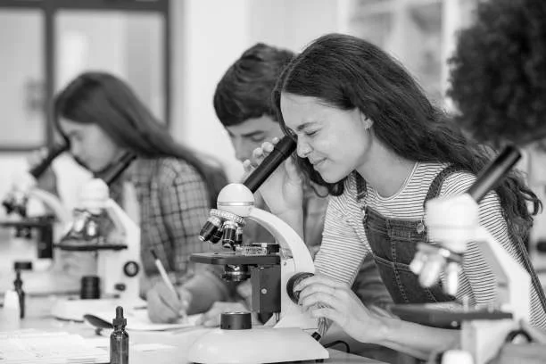 Children using microscopes in a classroom science lab.