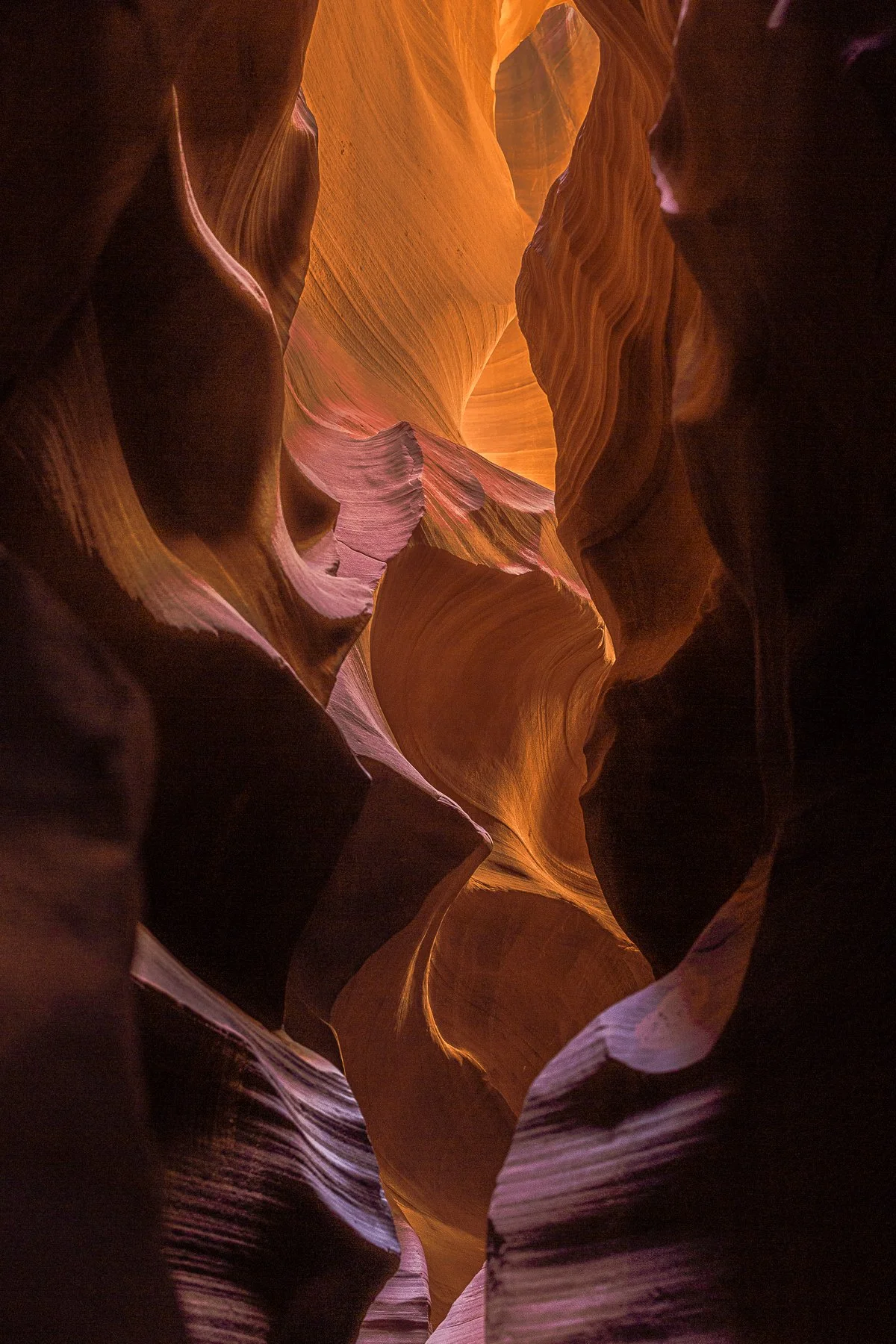 Antelope slot canyon with smooth, layered rock walls illuminated by warm, diffused sunlight.