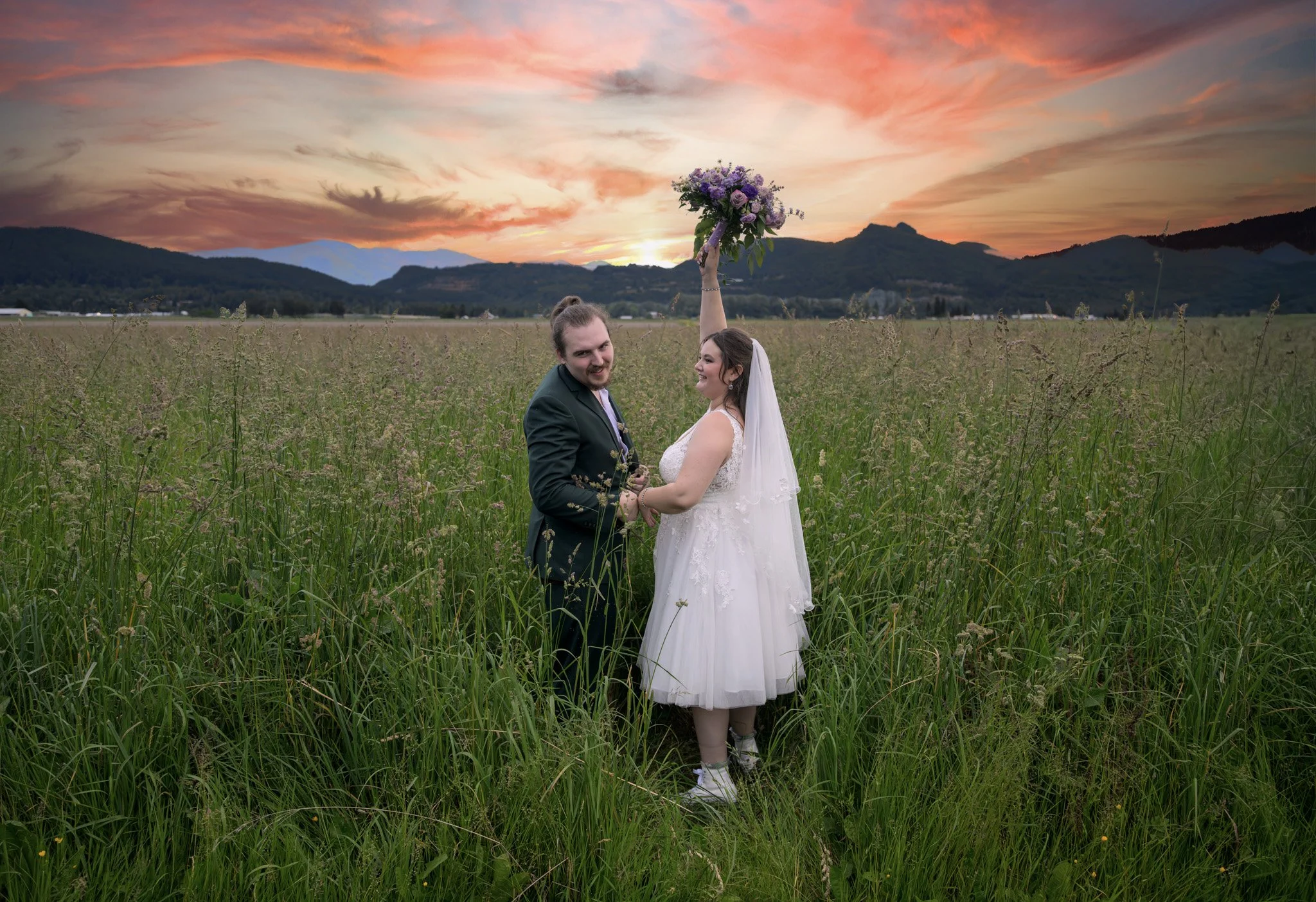 Bride and groom wedding portrait at sunset with mountains in the background.