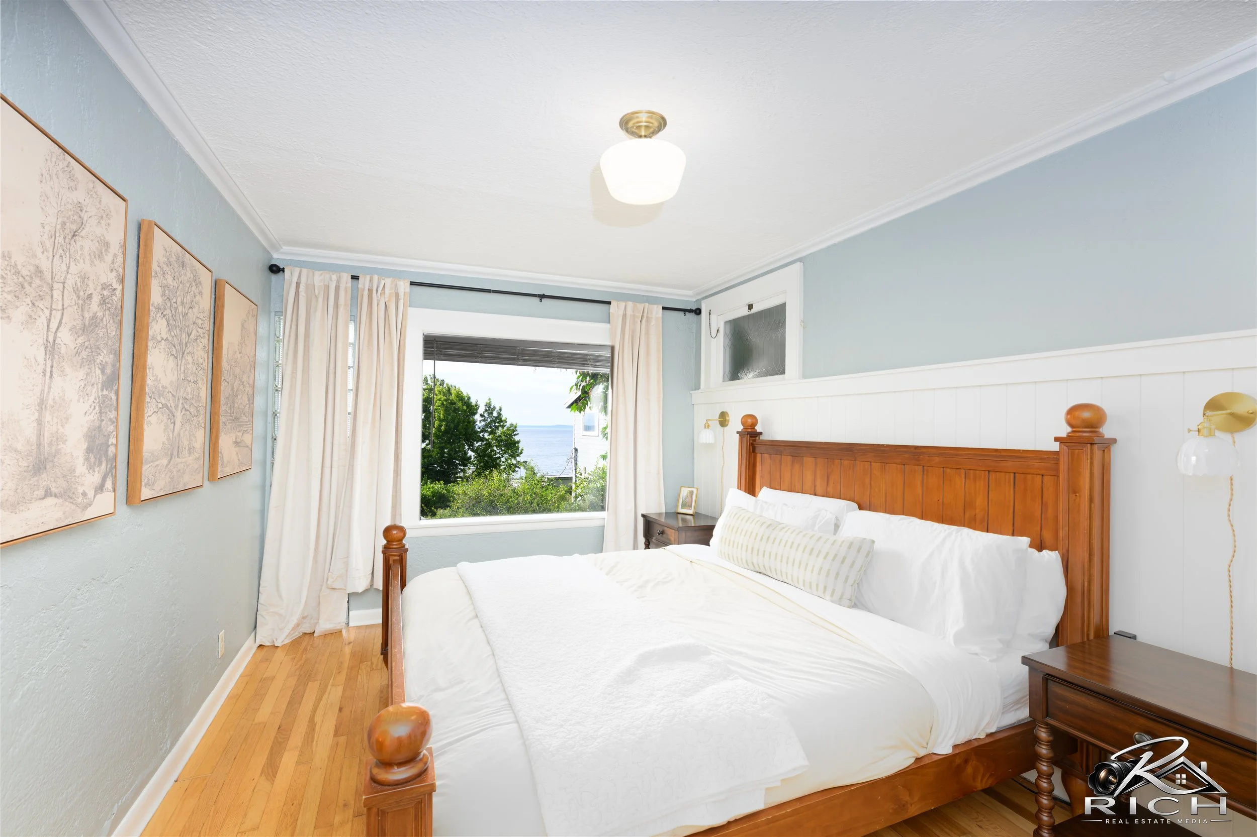Bright bedroom with ocean views photographed for a Seattle-area real estate listing.