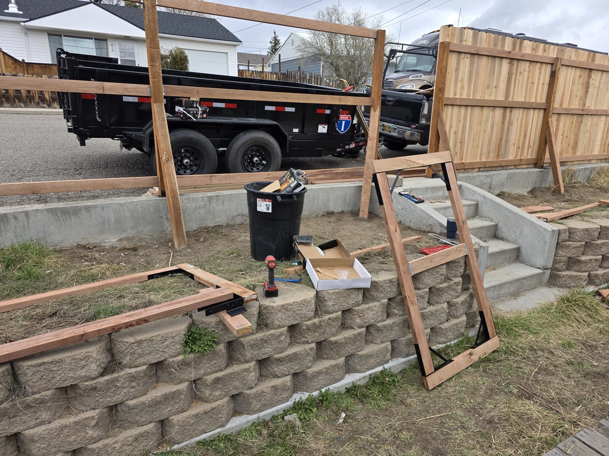 Dump trailer on site and the first cedar pickets going up in Walkerville, Montana