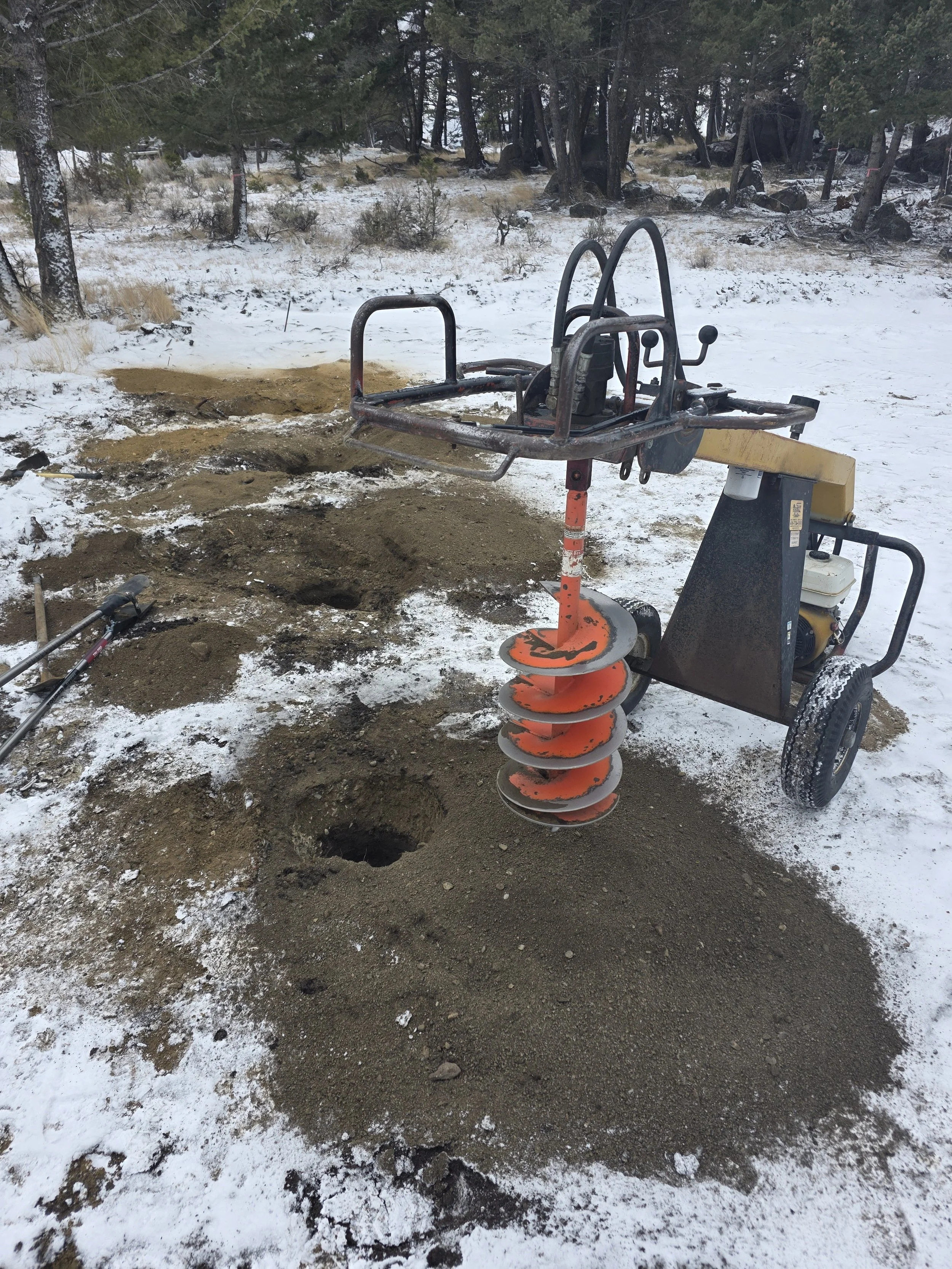 Augering post holes in the snow for the pole barn, Whitehall, Montana
