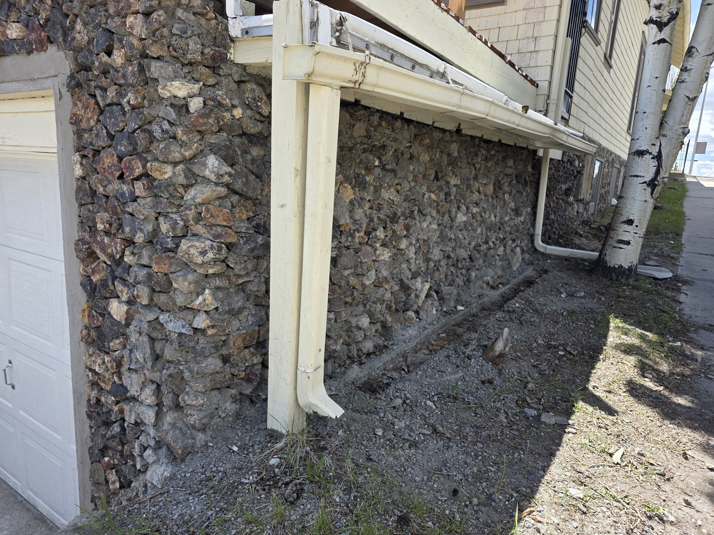 Finished historic rock garage wall seen from the corner, Butte, Montana
