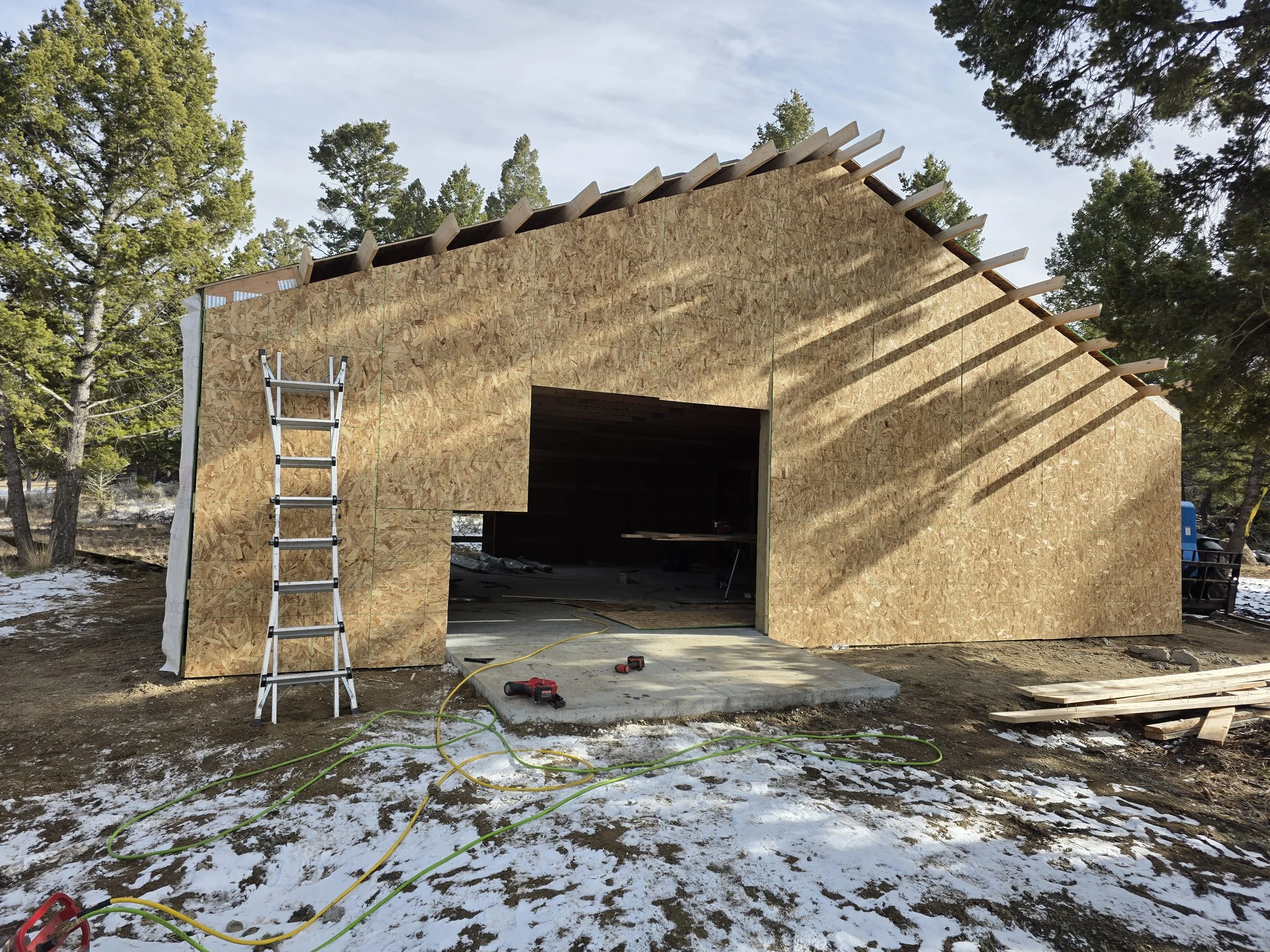 Pole barn shop sheathed with the overhead door opening framed, Whitehall, Montana