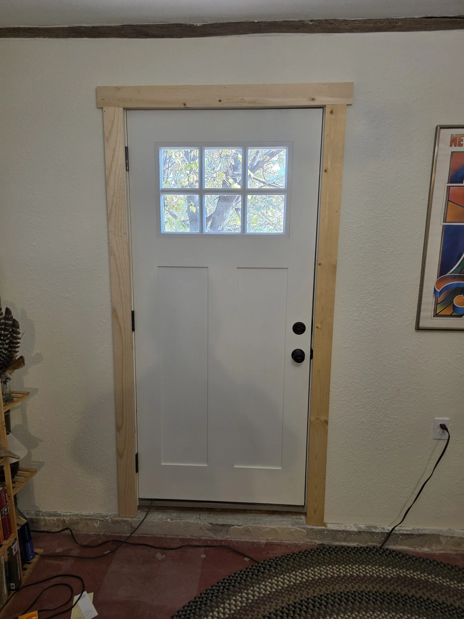 Inside of the new entry door with pine trim in a Cardwell, Montana bunkhouse