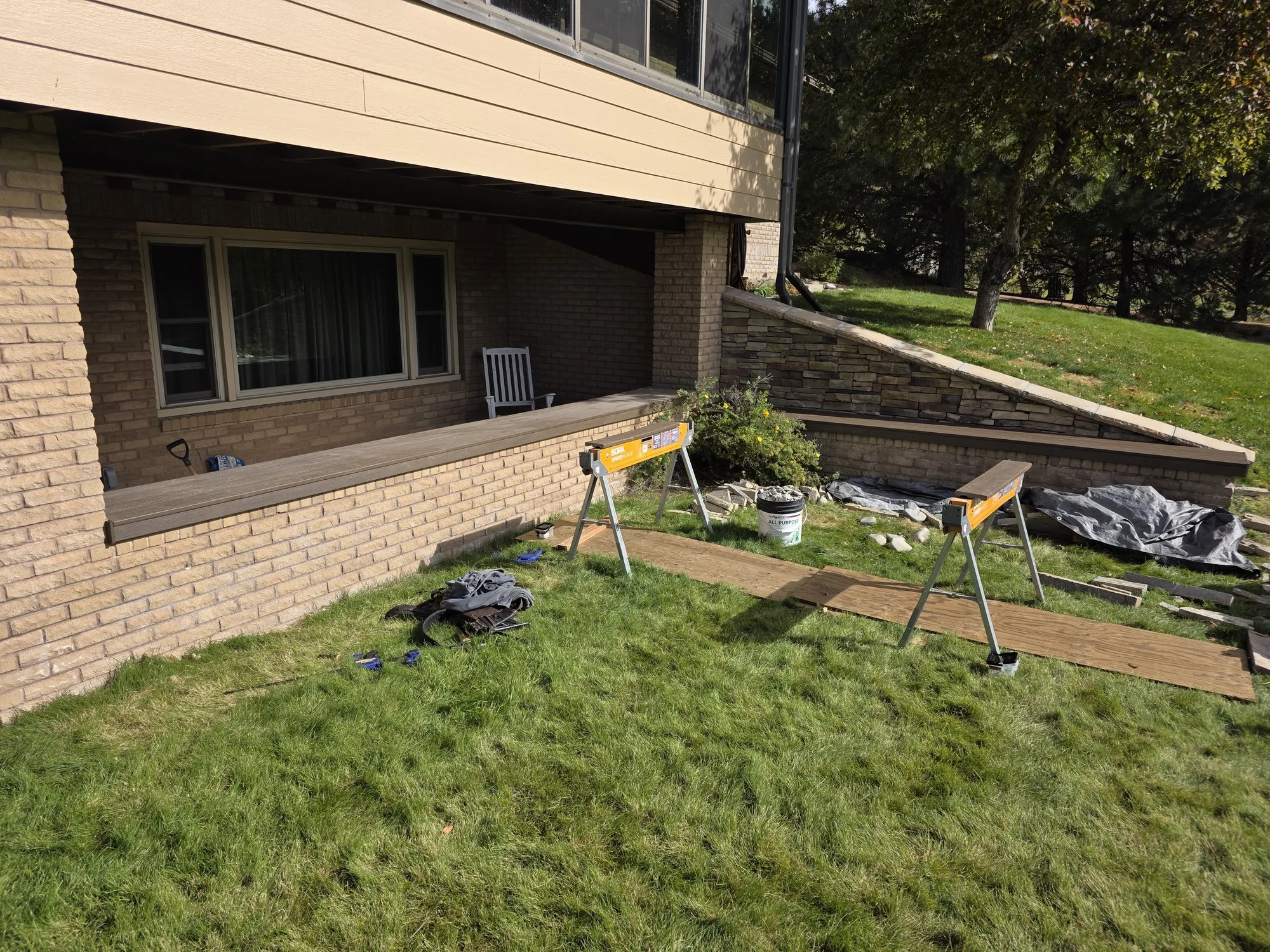 Composite bench covers on brick planters around a covered patio in Butte, Montana