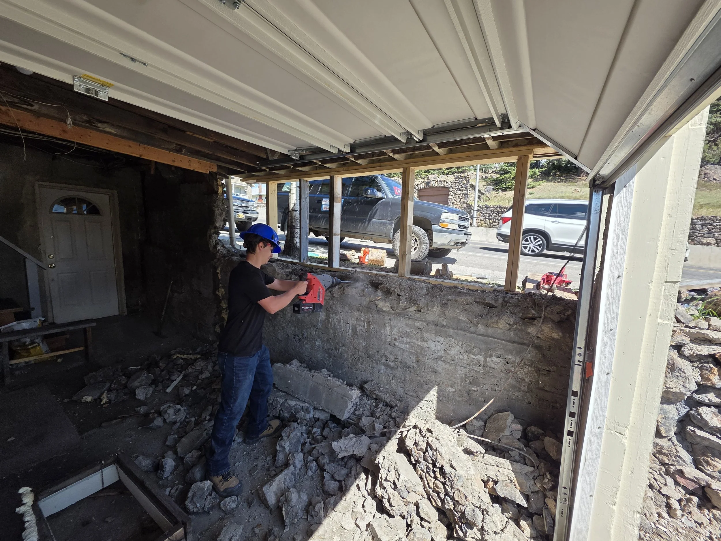 Clearing loose rock out of the damaged garage wall, Butte, Montana