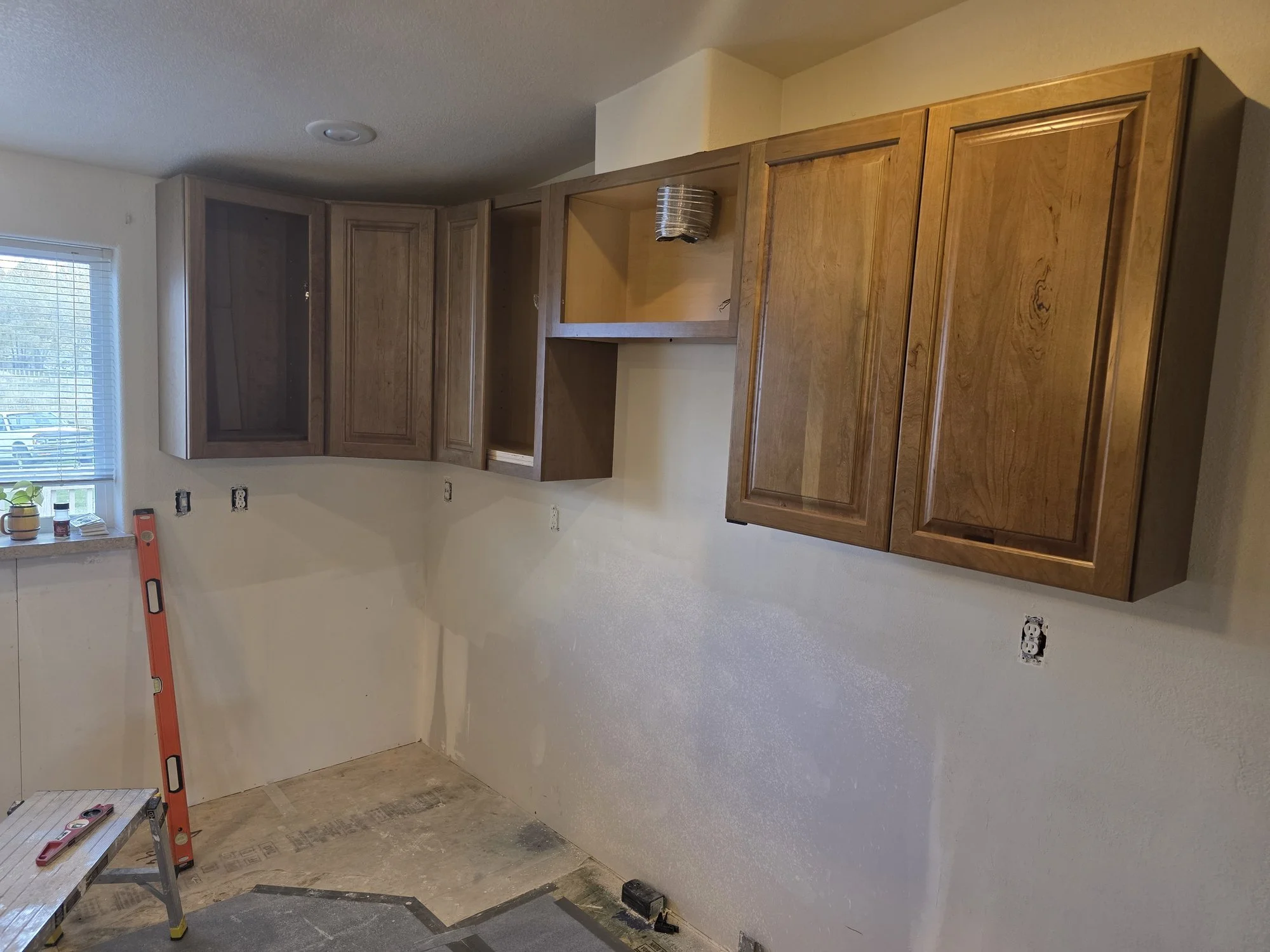 Upper cabinets going in at the corner of the Anaconda kitchen
