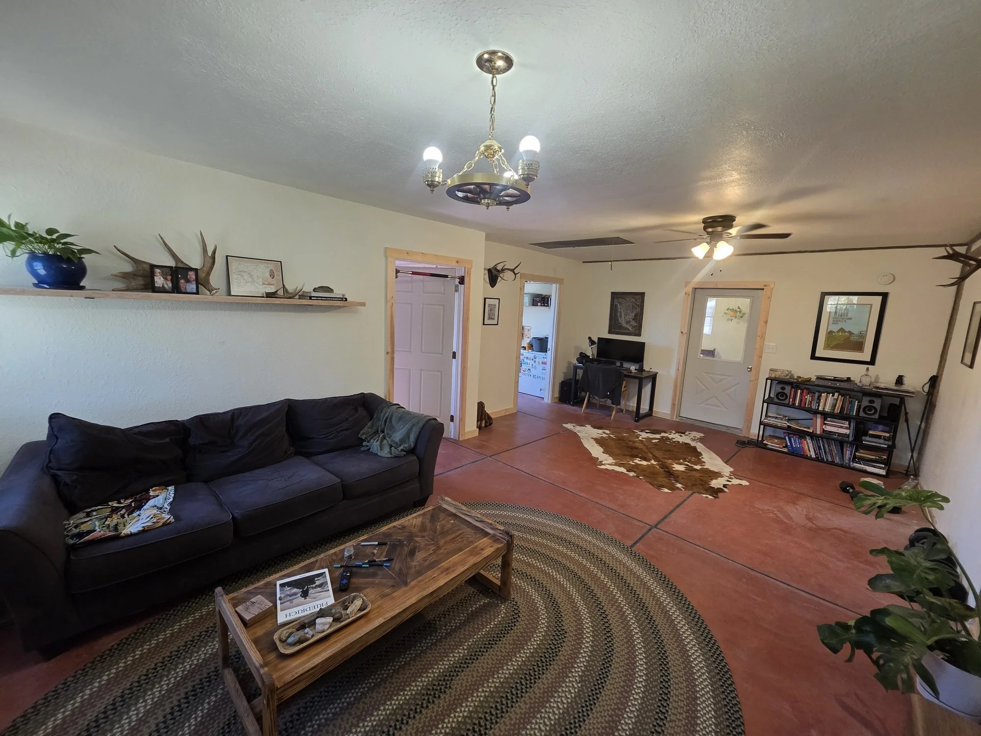 Finished bunkhouse living room near Cardwell, Montana with exposed ceiling beams, new drywall and painted trim