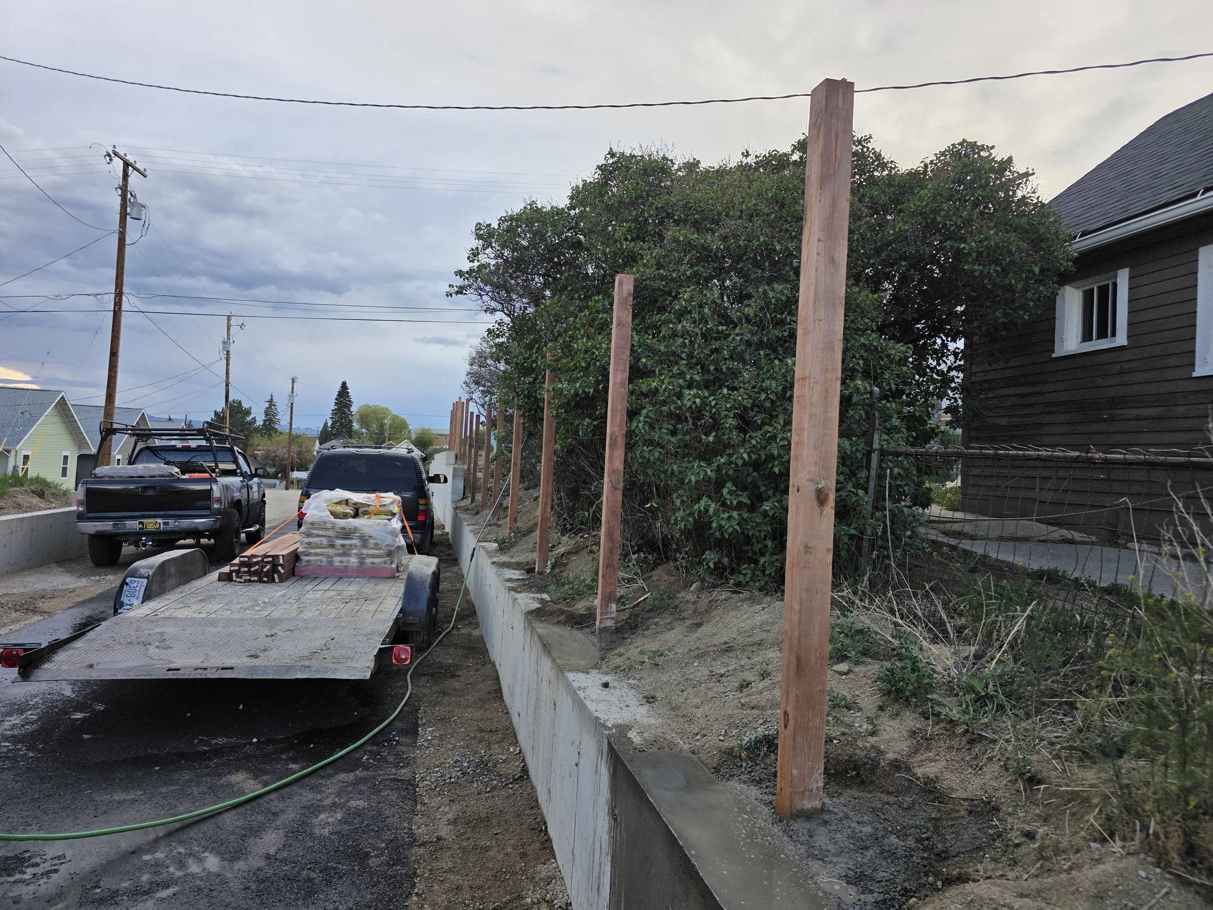 Fence posts set behind the retaining wall, Uptown Butte, Montana