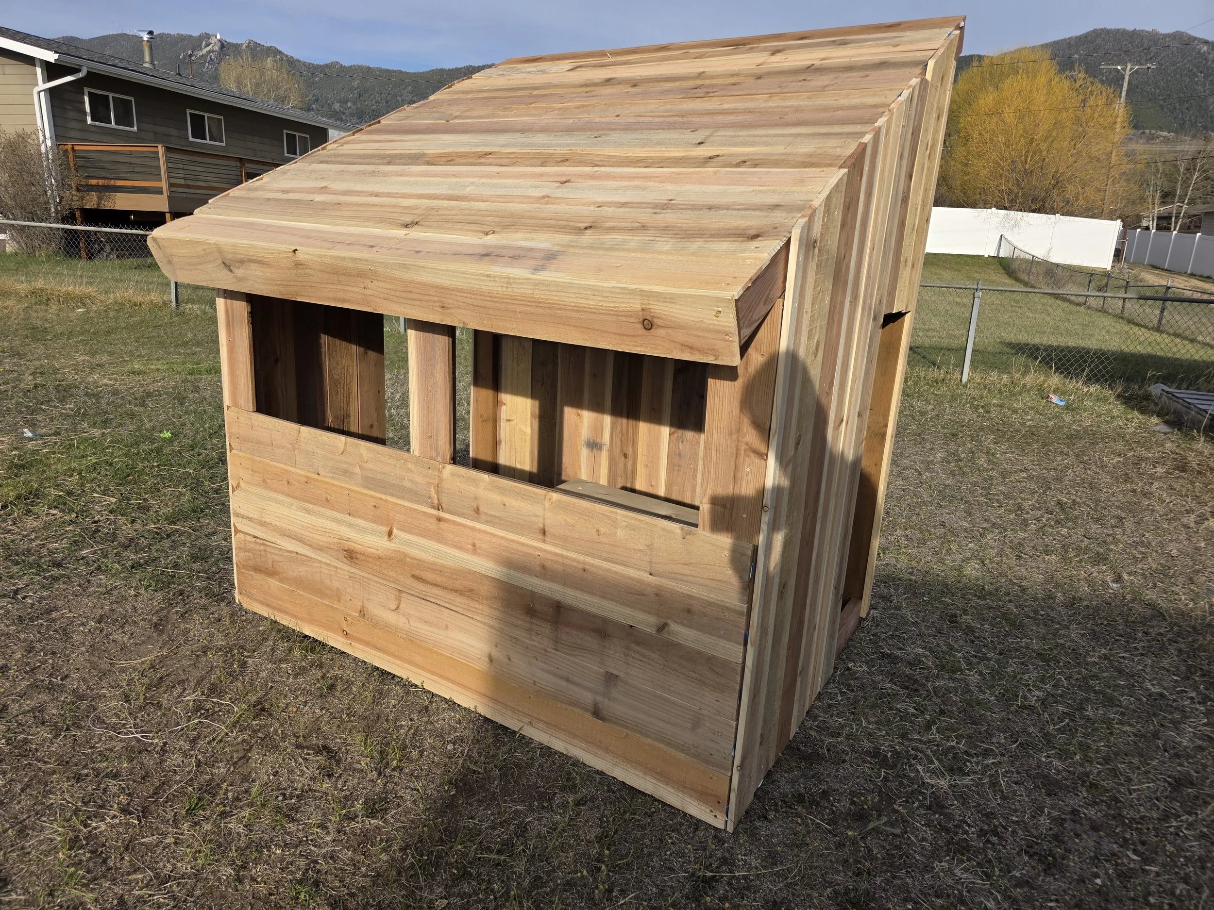 Cedar playhouse with a shed roof and open windows, near Belgrade, Montana