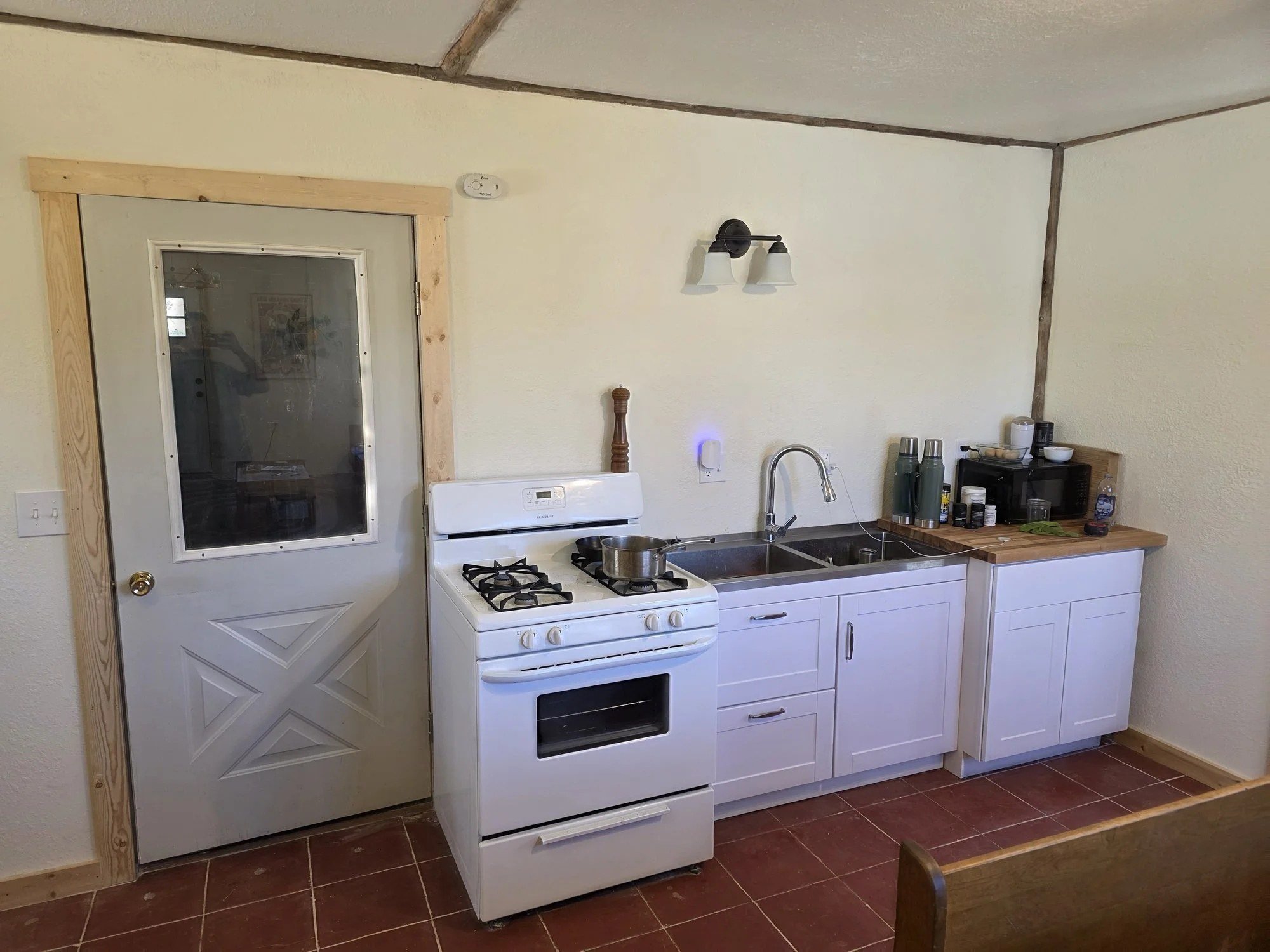 Rebuilt bunkhouse kitchen with new cabinets, counters and a new exterior door, Cardwell, MT
