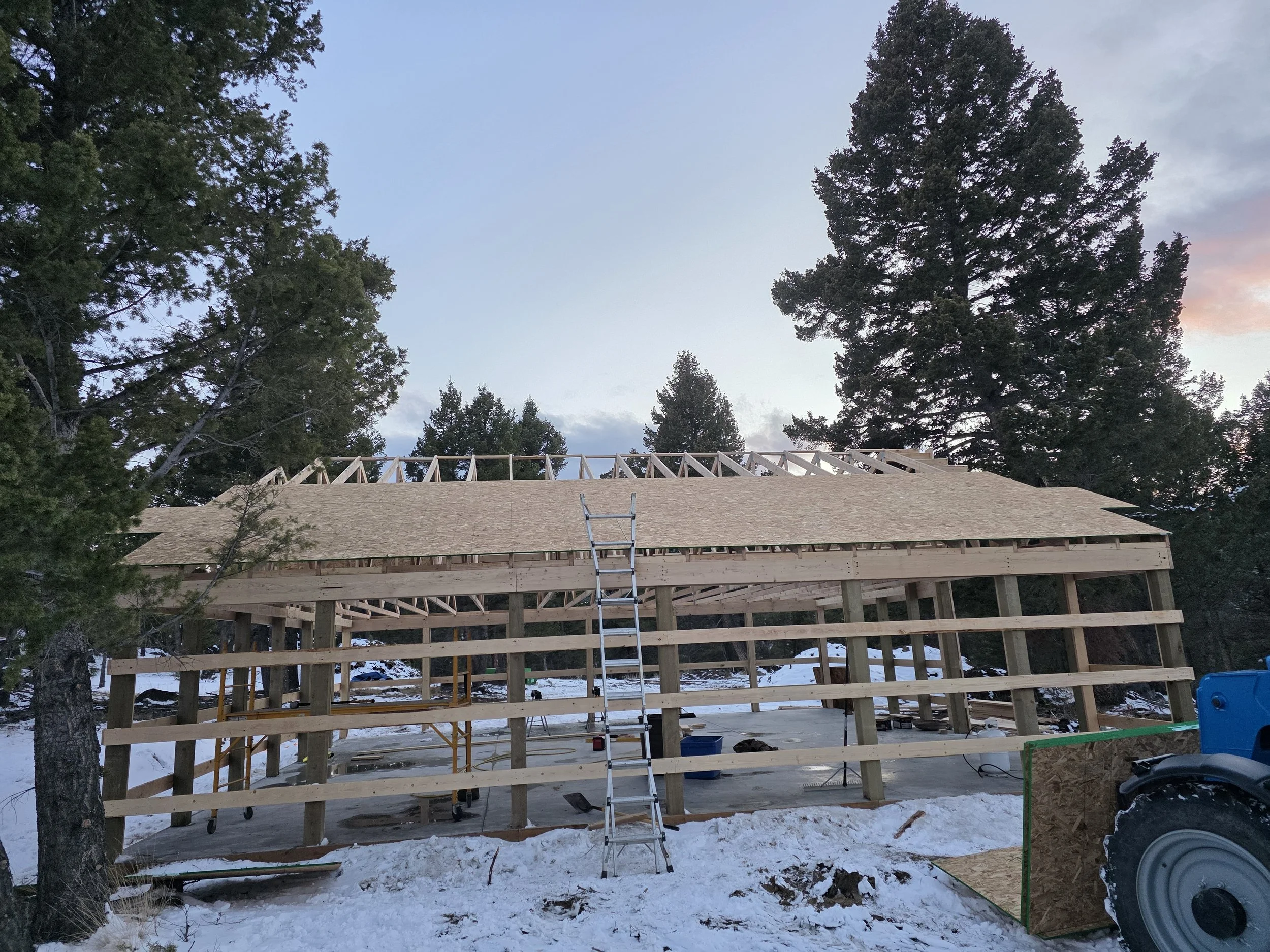 Roof sheathing going on the pole barn shop in winter, Whitehall, Montana