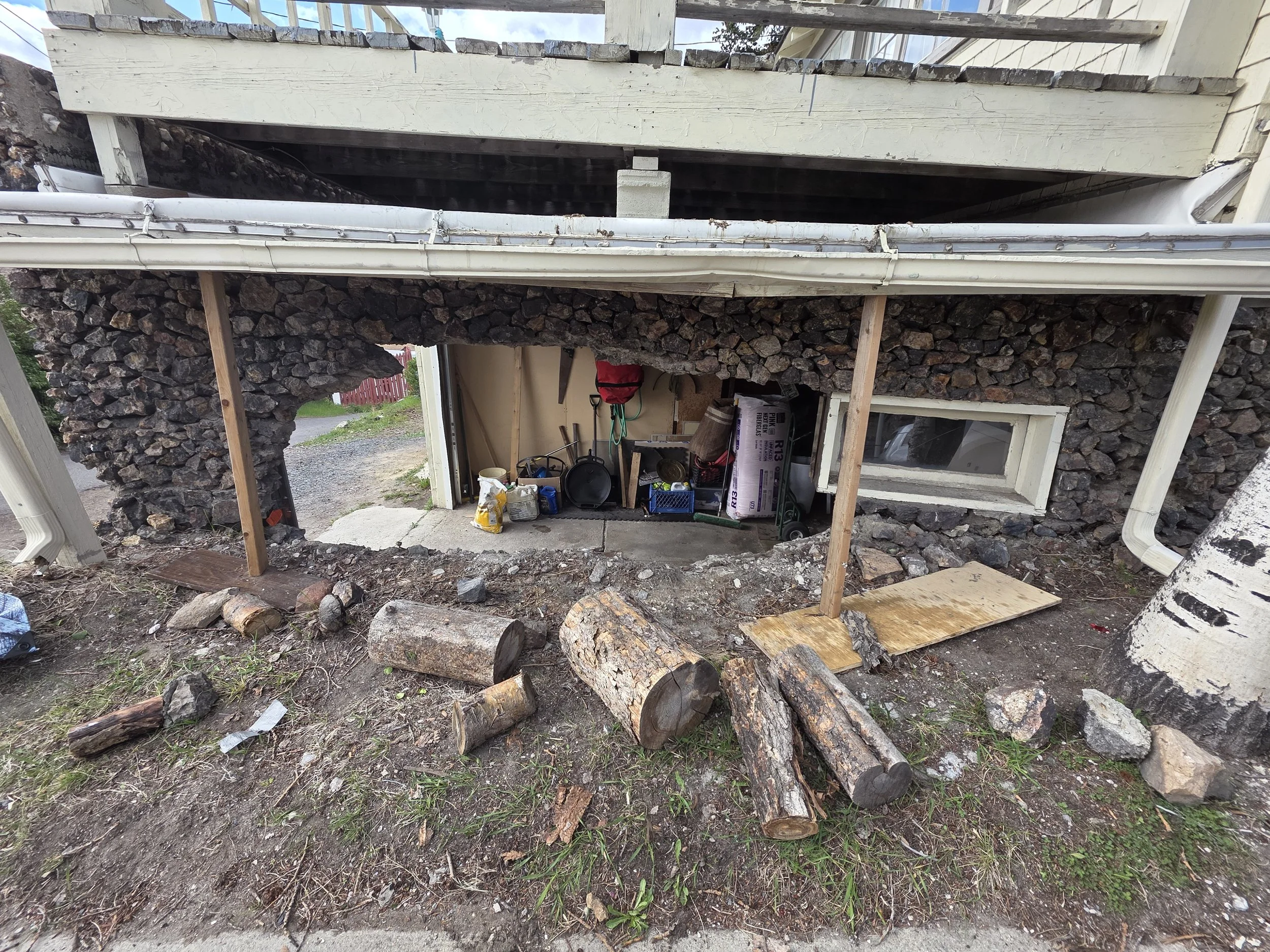 Hole knocked through a 100-year-old rock garage wall after a vehicle hit it, Butte, Montana