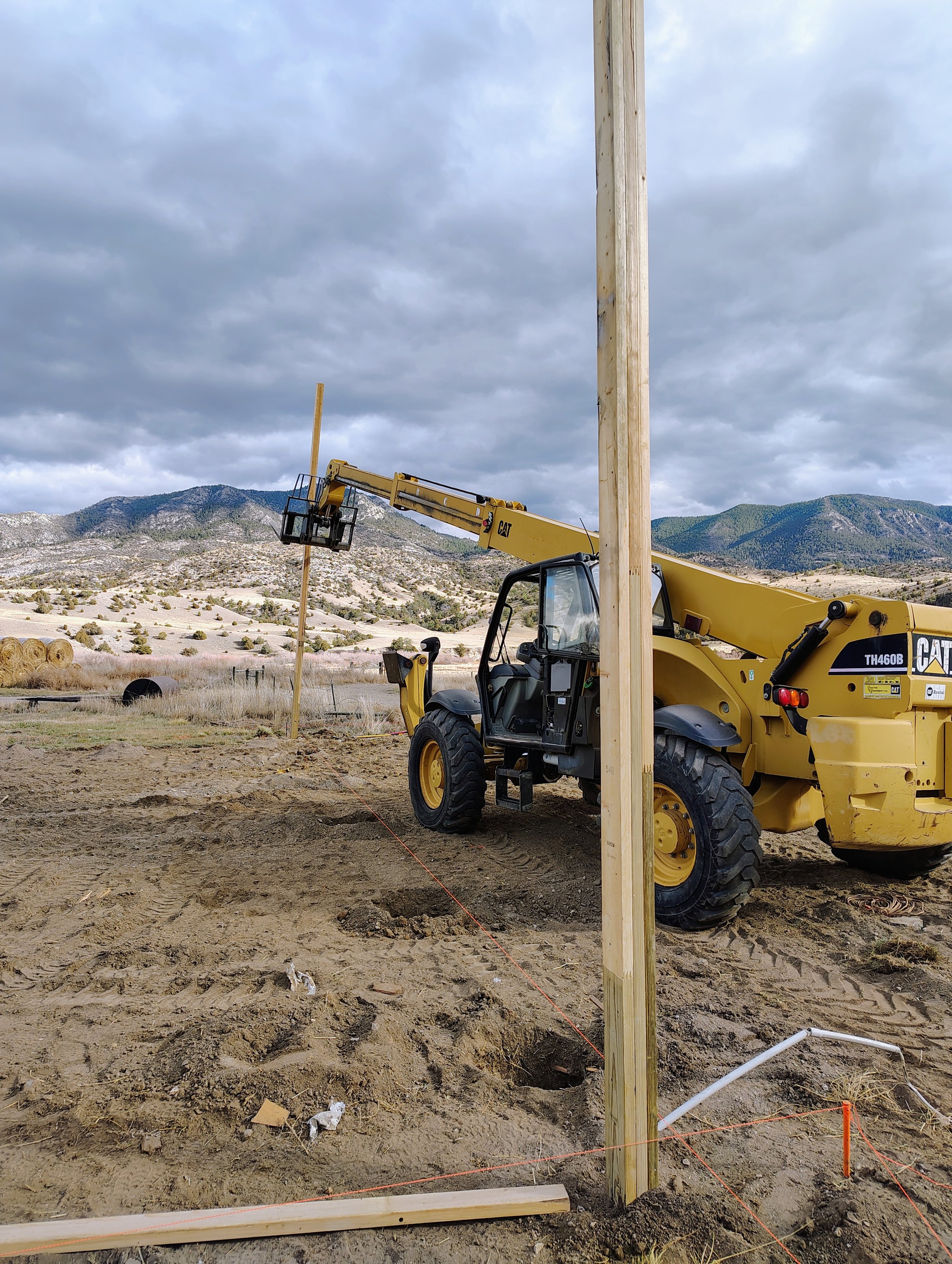 Setting the first posts with a telehandler for a 40x60 pole barn, Cardwell, Montana