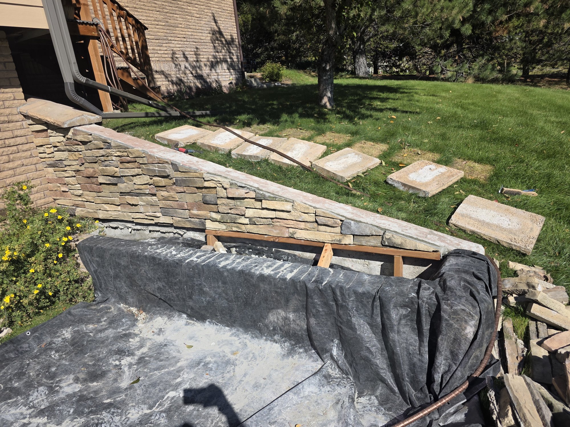 Wall caps removed and old mortar cleaned out of the stone veneer planter wall, Butte, Montana