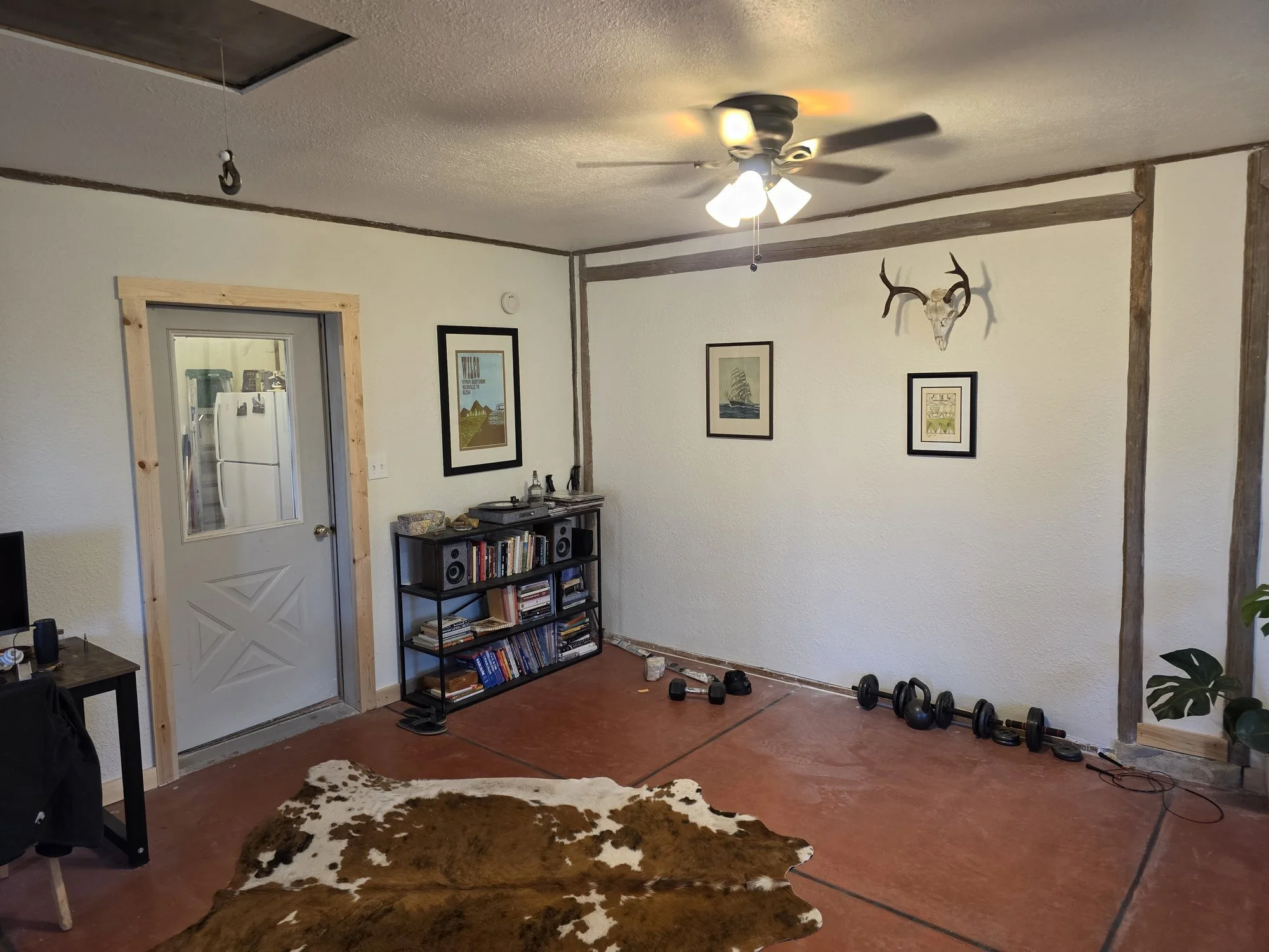 Corner of the bunkhouse living room with exposed beams and new drywall, Cardwell, Montana