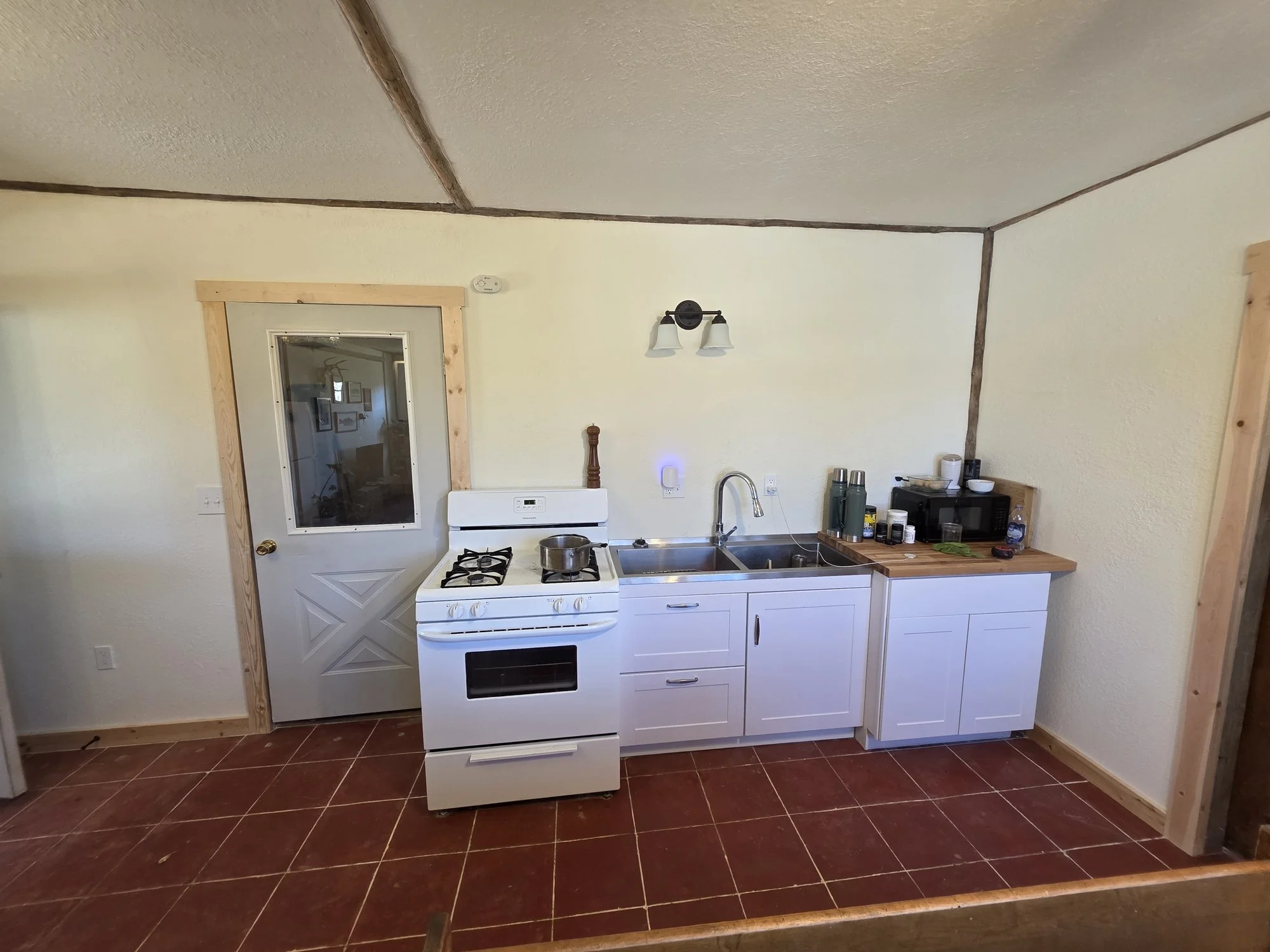 New kitchen sink run with cabinets and countertop in a Cardwell, Montana bunkhouse