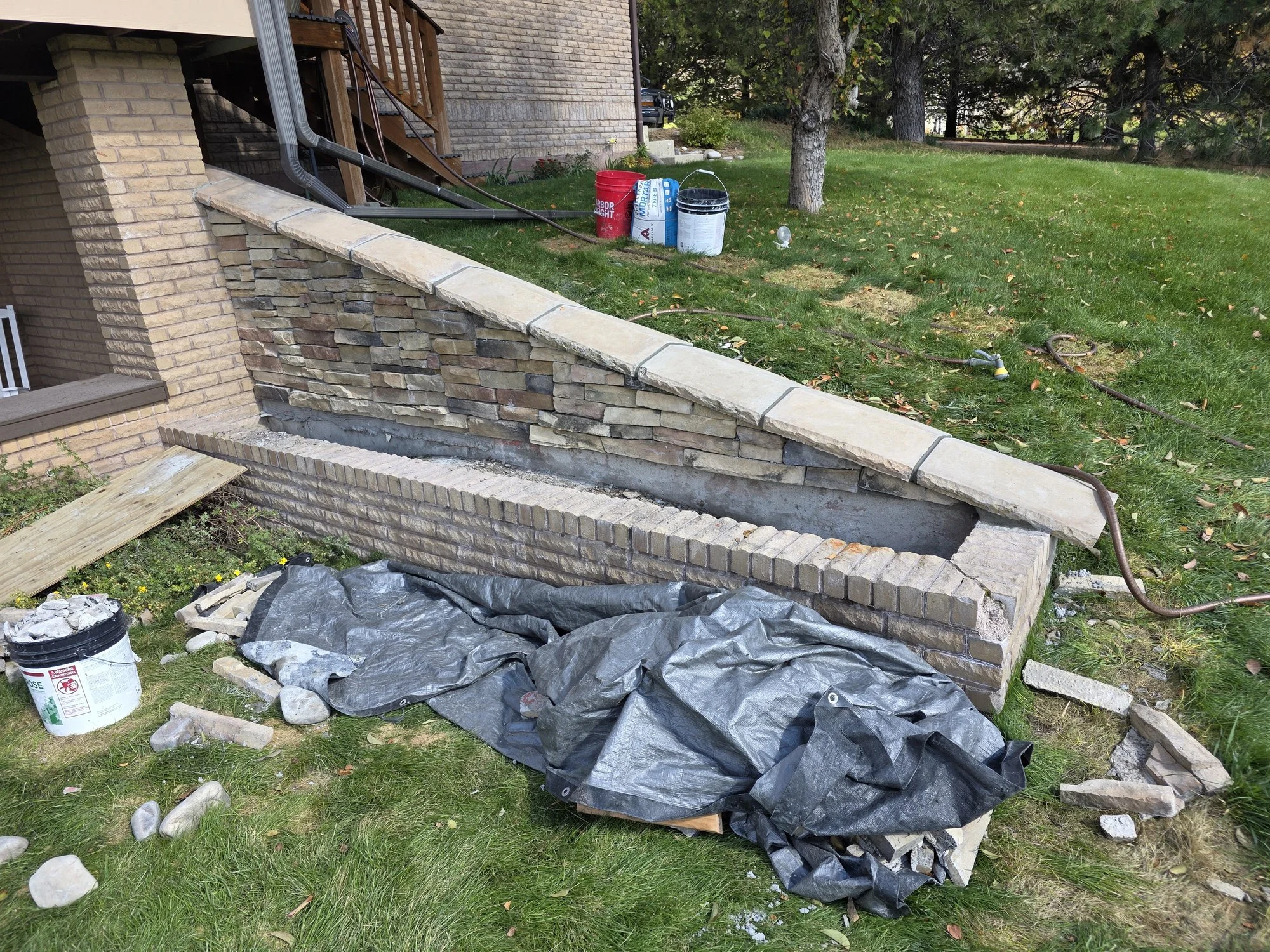 Stone caps reset level in fresh mortar with tooled joints, Butte, MT planter wall
