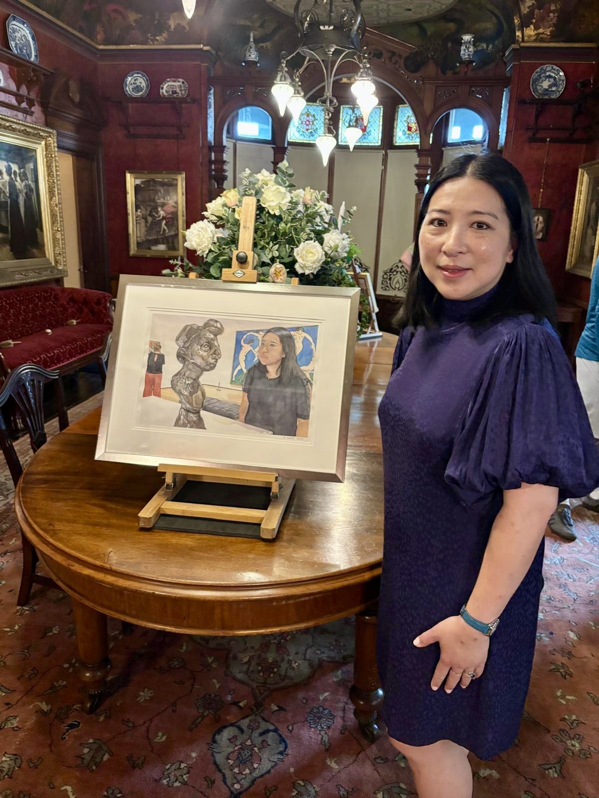 Aki with her self-portrait Tête-à-Tête at the Ruth Borchard Collection Self Portrait Prize Exhibition in the Russell Cotes Museum in Bournemouth, England