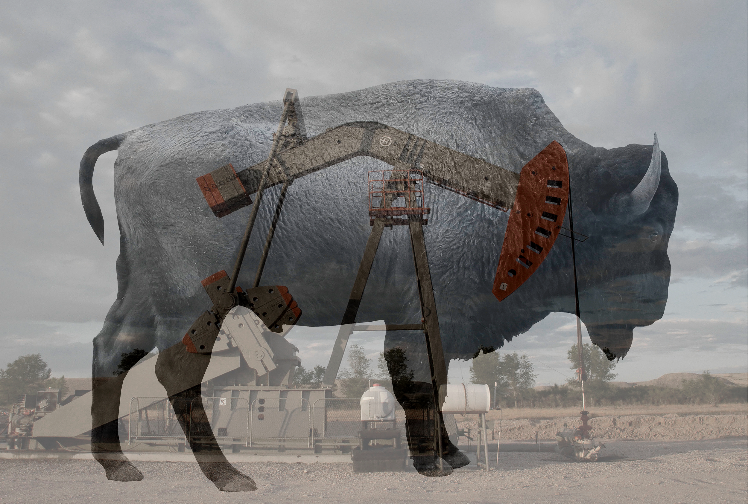A desert scene with an overcast sky and a large cow sculpture made of metal cargo containers, with a construction lift in front of it.