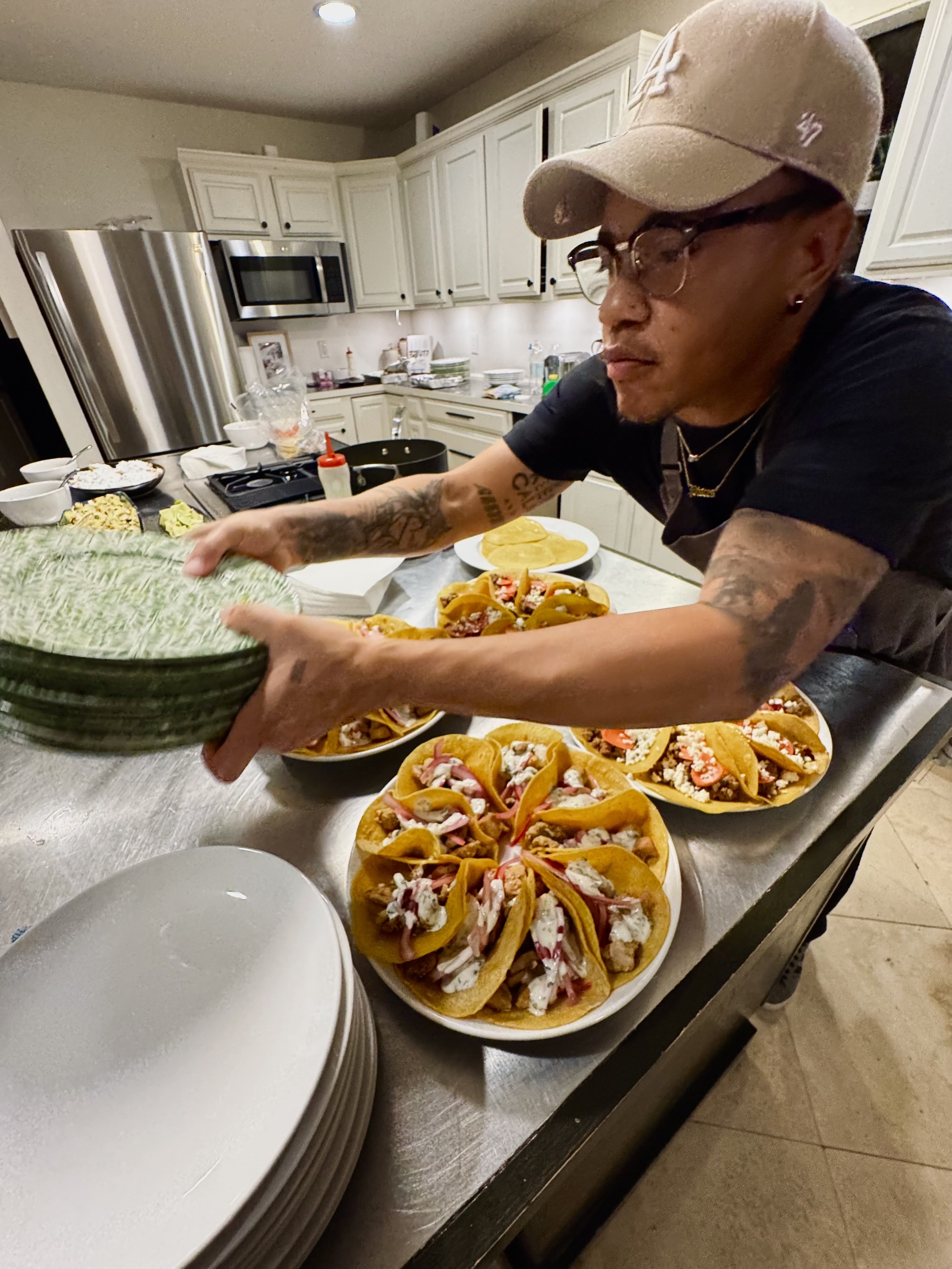 Chef Dom Every preparing taco plates in a kitchen.