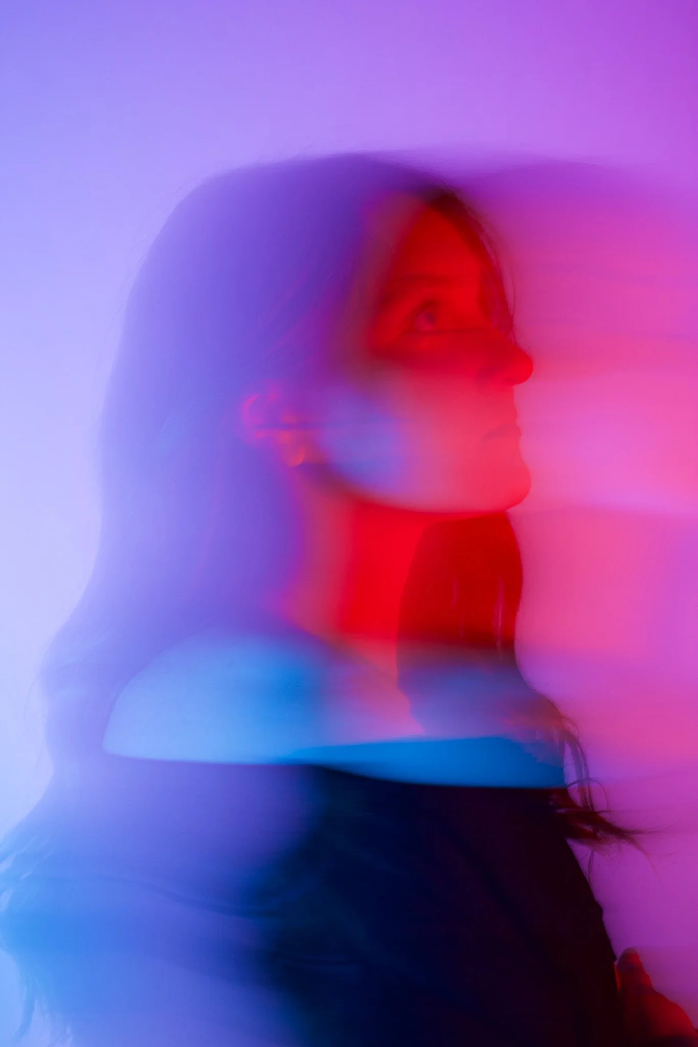 Abstract, colorful digital art of a person's profile with neon blue, purple, and red hues blending together.