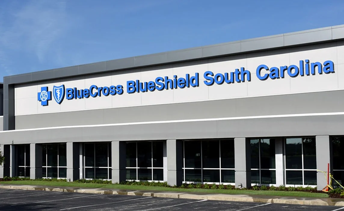 Exterior view of a building with a sign that reads 'BlueCross BlueShield South Carolina' and a blue logo on a clear day.
