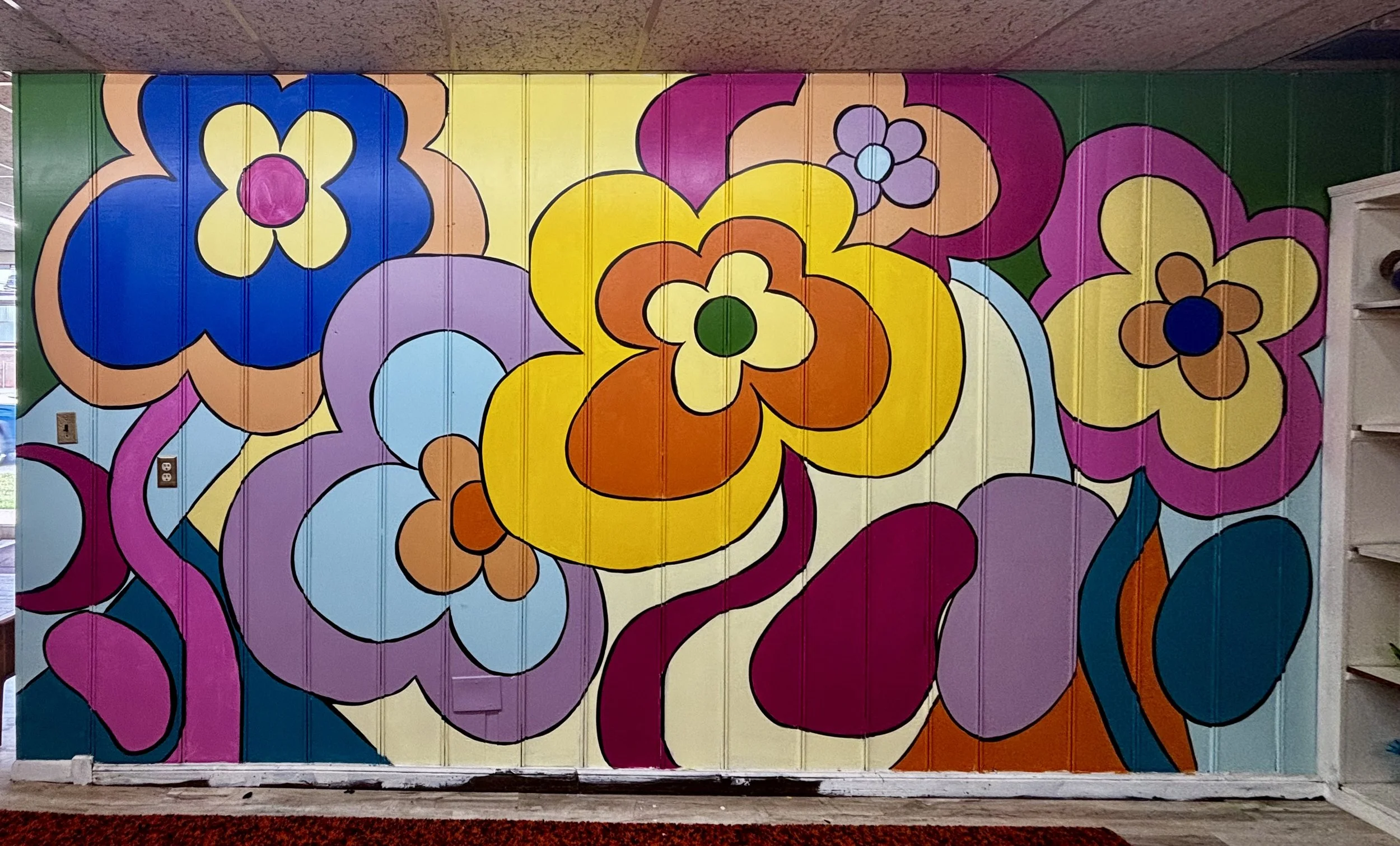 Colorful mural of flower patterns painted on a large wall.