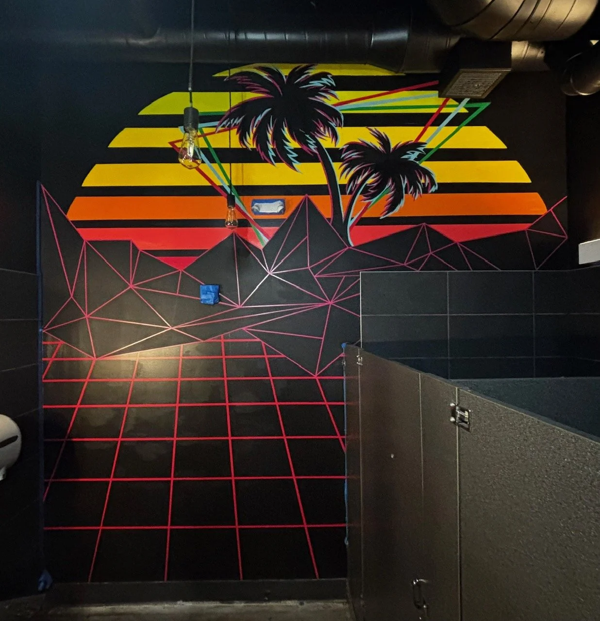 Neon wall art featuring a sunset with yellow, orange, and red stripes, silhouettes of palm trees, and a geometric grid landscape with pink lines.