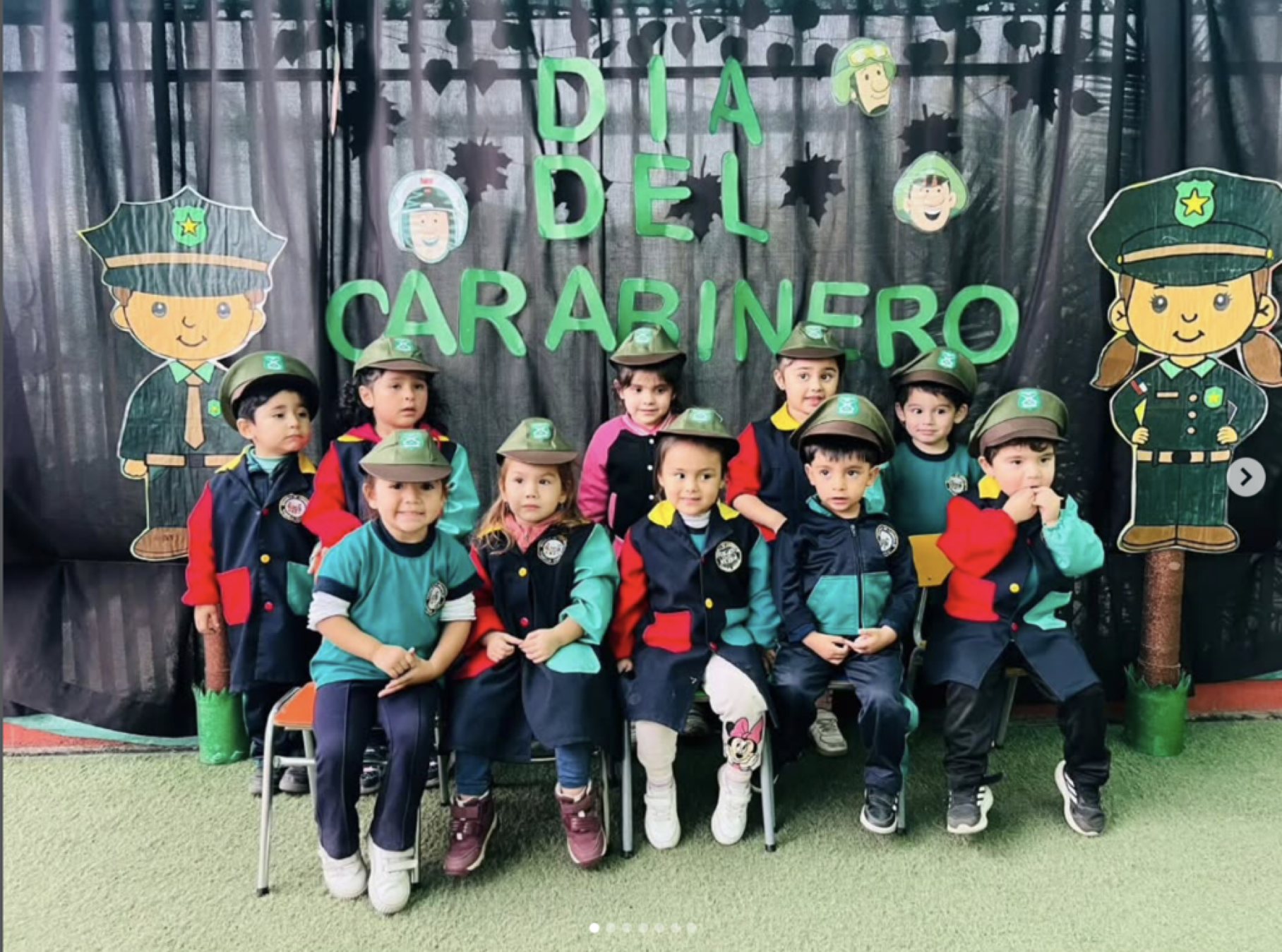 Niños disfrazados de policías en una celebración del Día del Carabinero, con decoraciones de policías y un fondo de bosque.