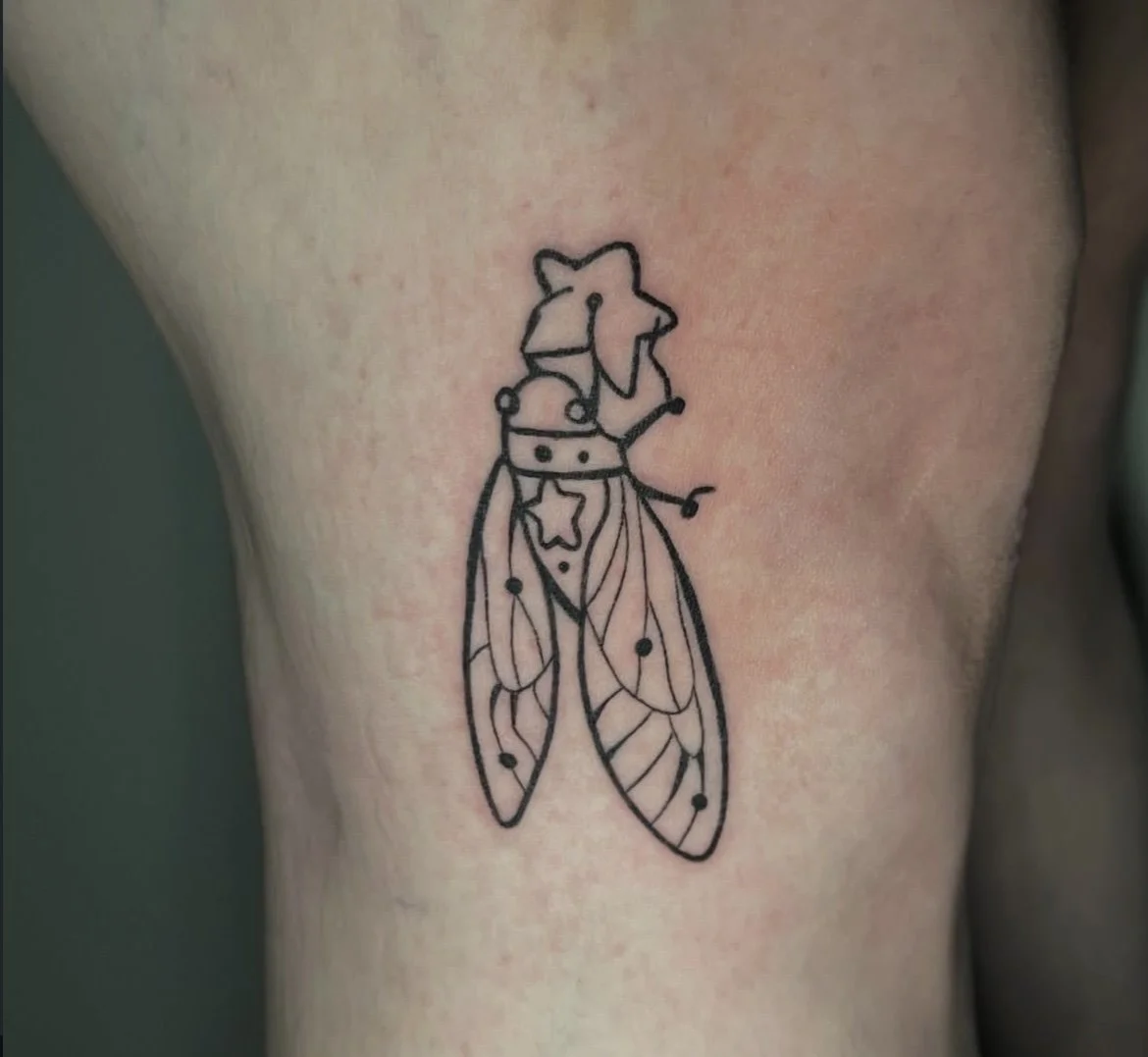 Line art tattoo of a fairy with butterfly wings and a star near its chest, wearing a crown.