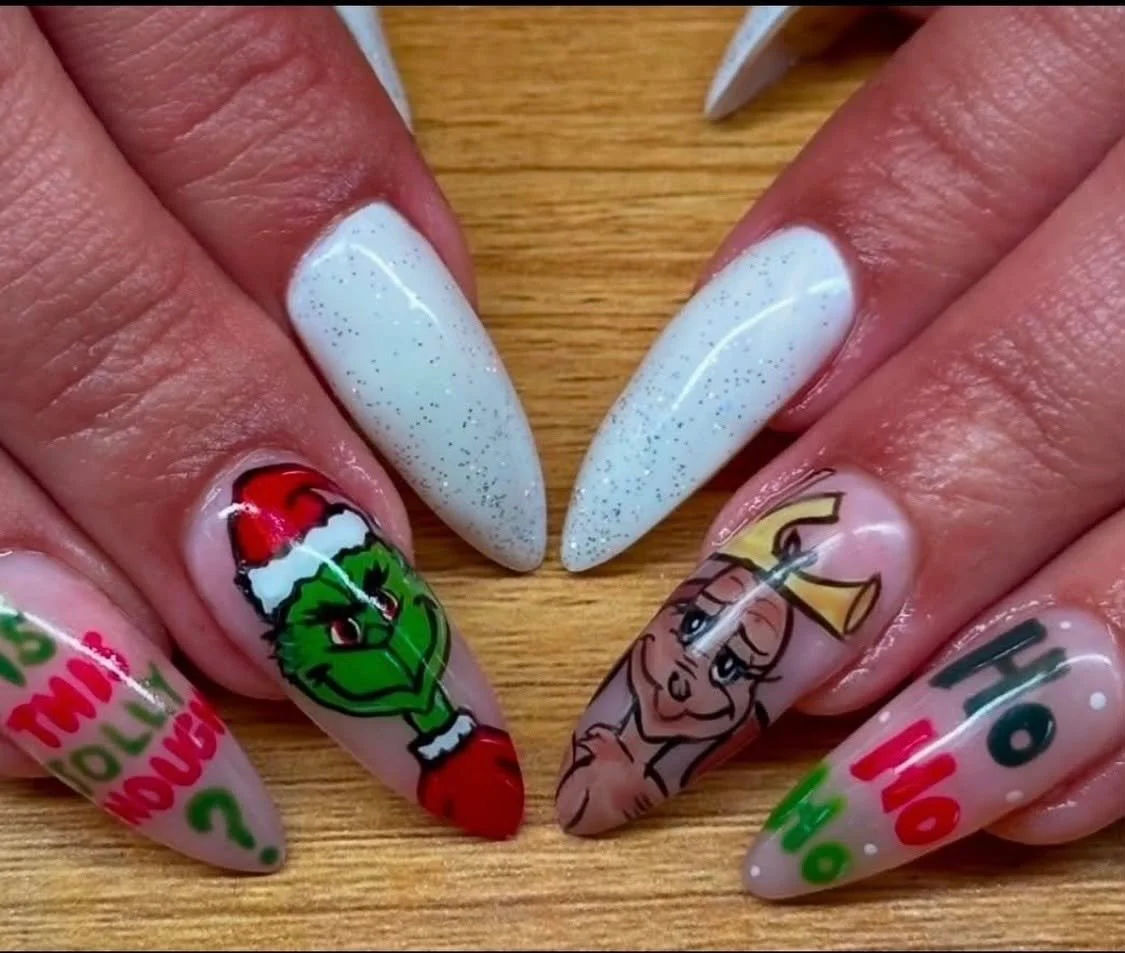 Yarn nails with Christmas-themed decorations, including a Grinch with a Santa hat and a cartoon character resembling Mrs. Claus, on decorated nails.
