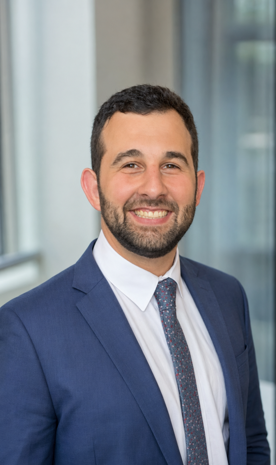 Jacob Markarian in a navy suit and tie, smiling.