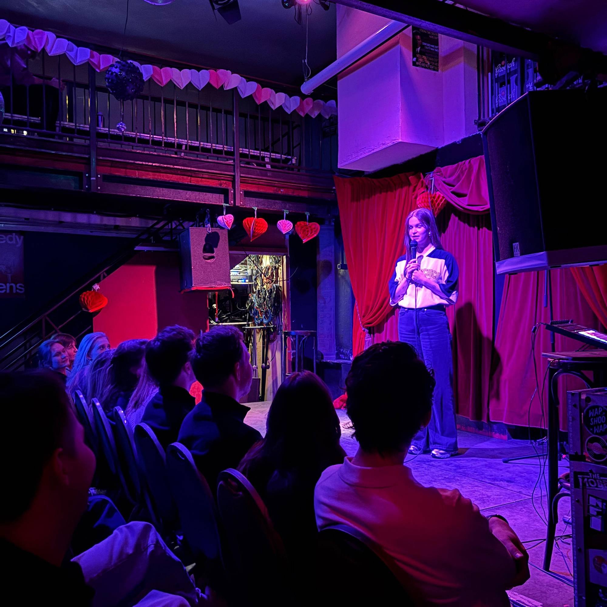 Foto van de Valentijnseditie van Comedy Queens met vrouwelijke comedian op het podium