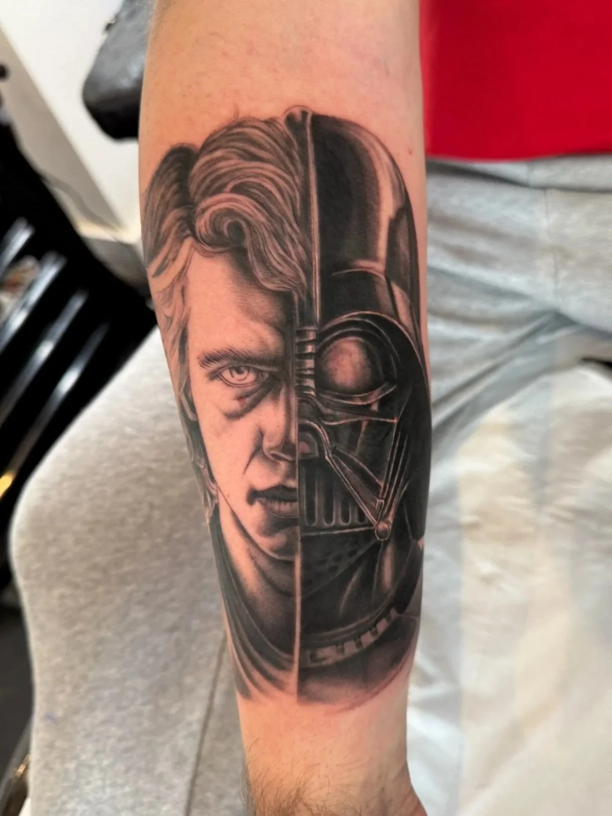 Tattoo of a woman's face and Darth Vader's helmet, split down the middle, on a person's arm.