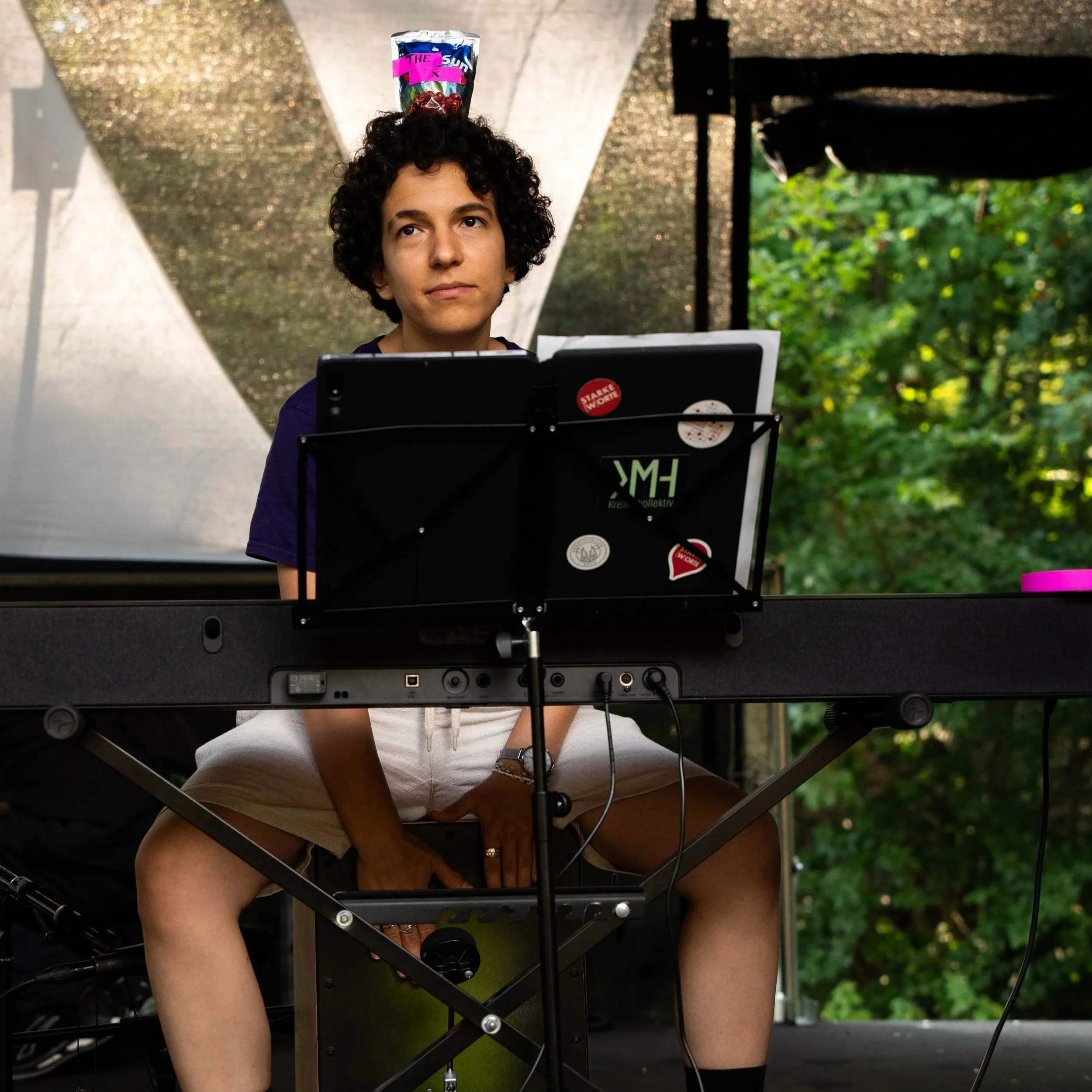 Eine Musikerin spielt auf einem E-Piano im Freien.