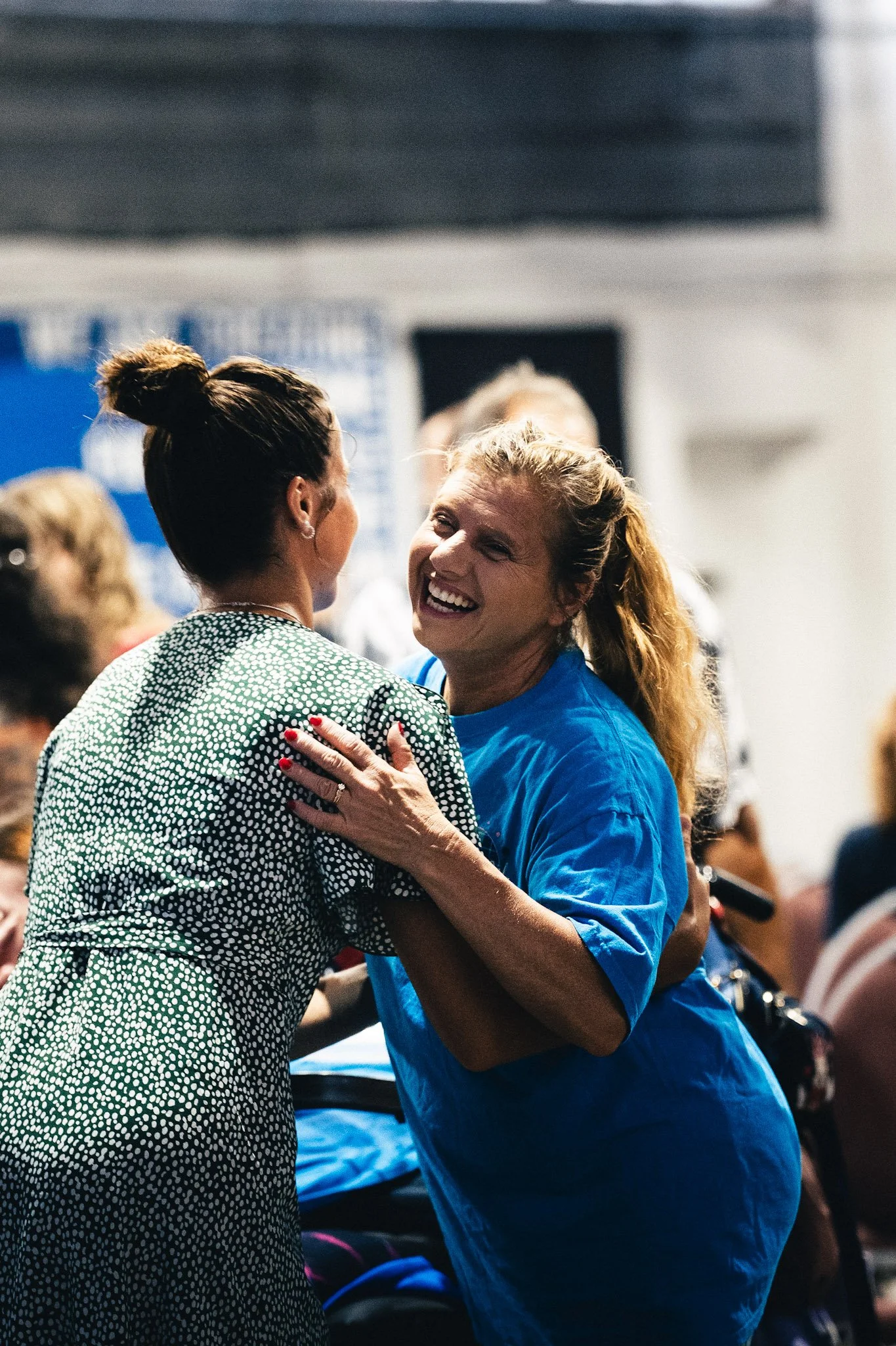Two women smiling and embracing at Altered Church.
