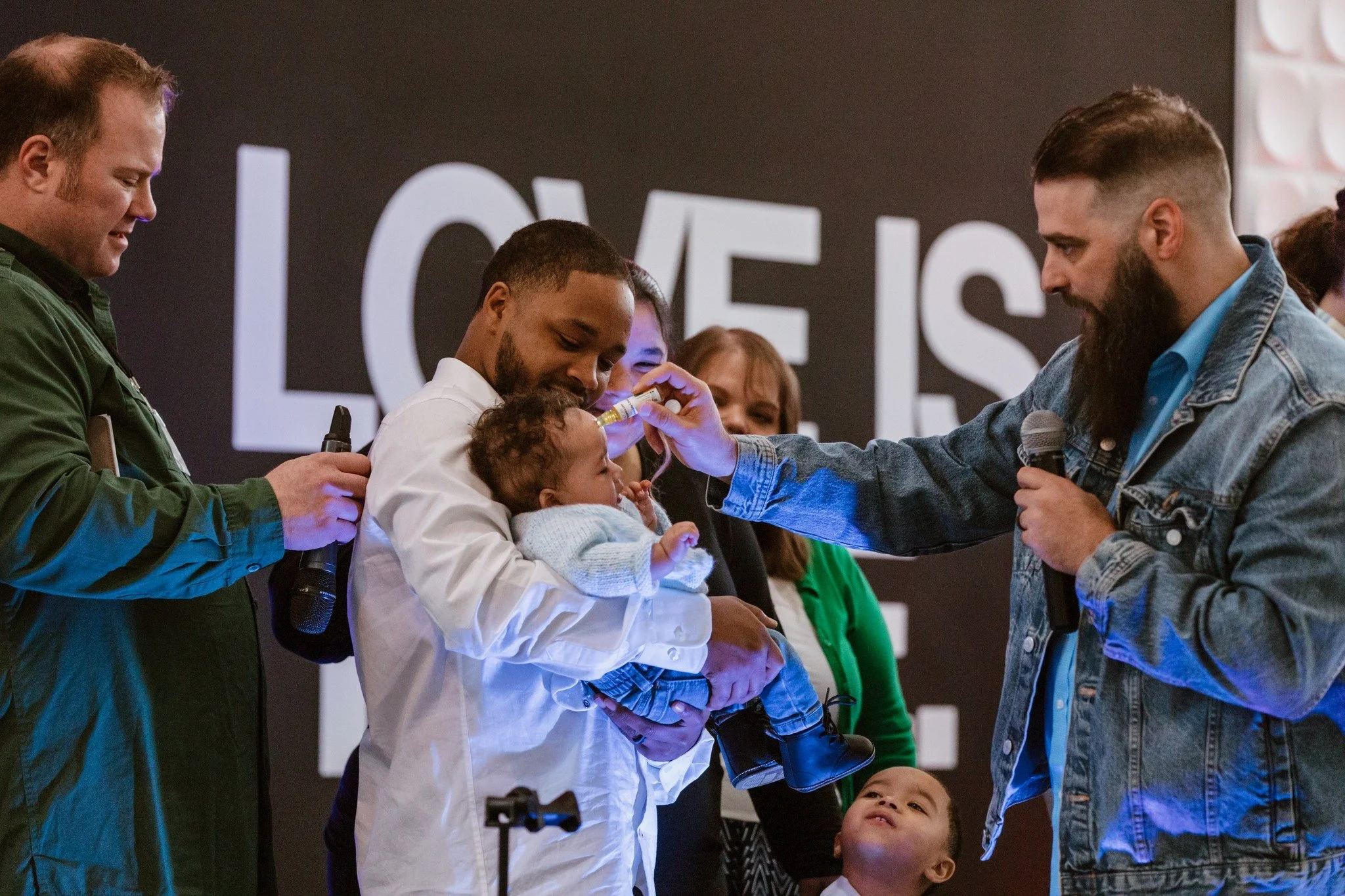 Adults gathered around a child at a church celebration.