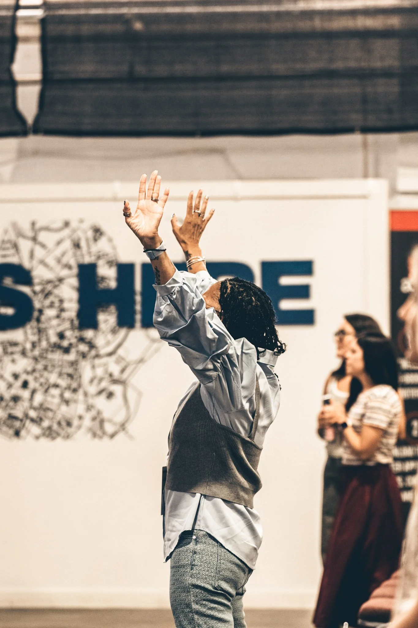 Worshipper raising both hands during a gathering at Altered Church.