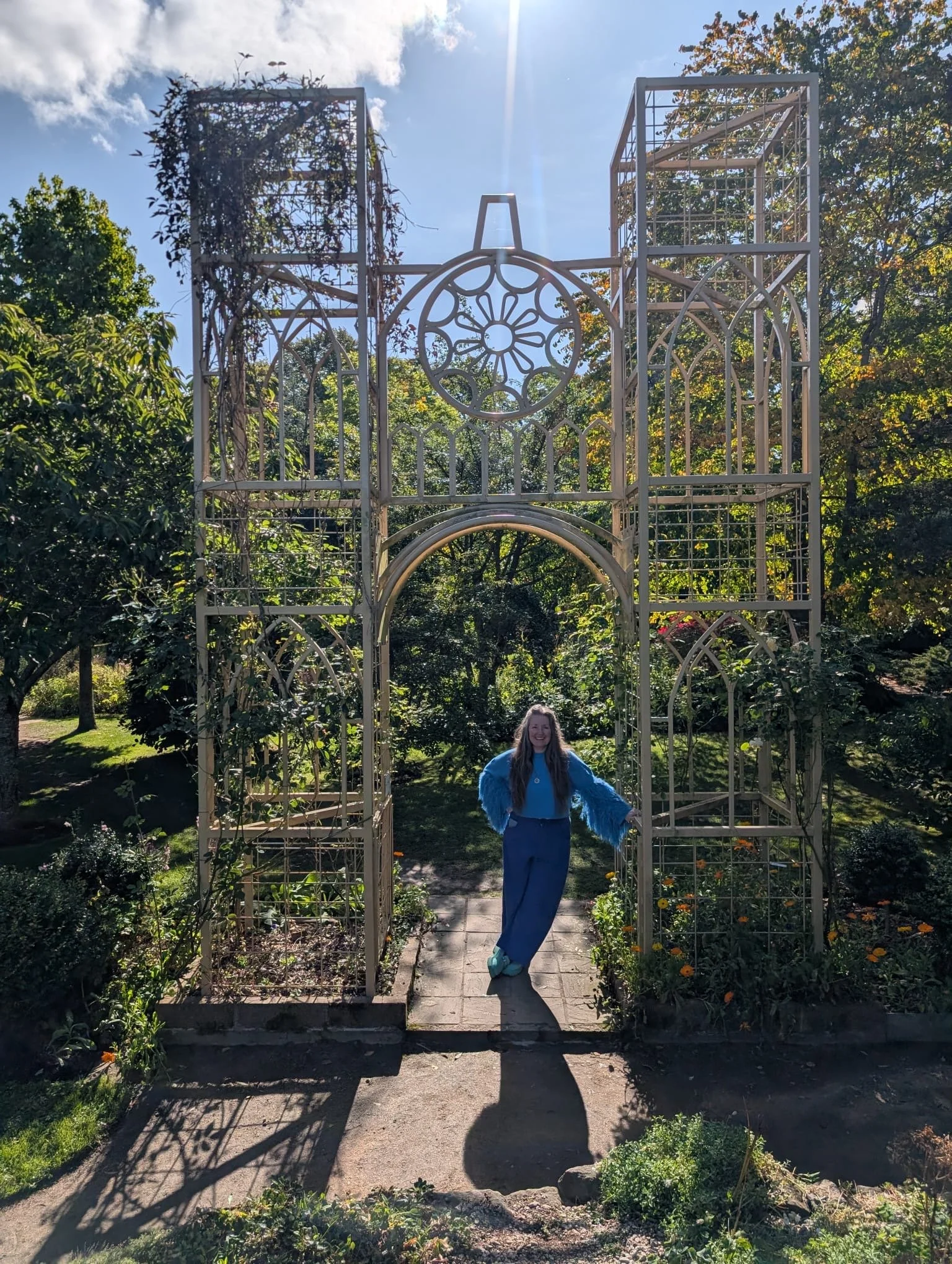 Rev. Bunny Love-Schock standing at the entrance to a garden