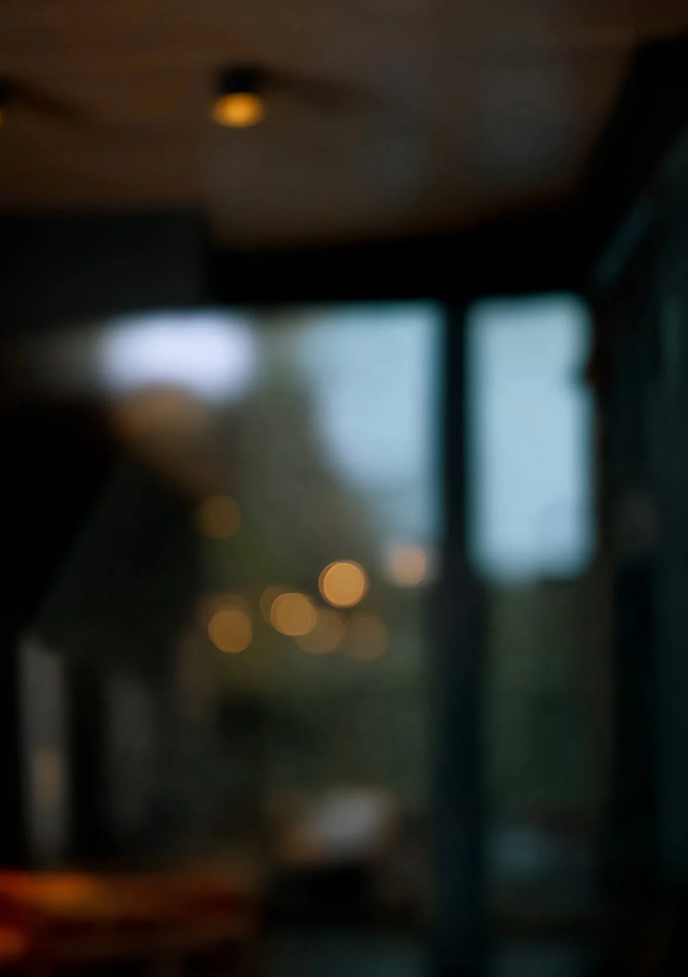Blurred interior view of a building with lights and windows in the background.